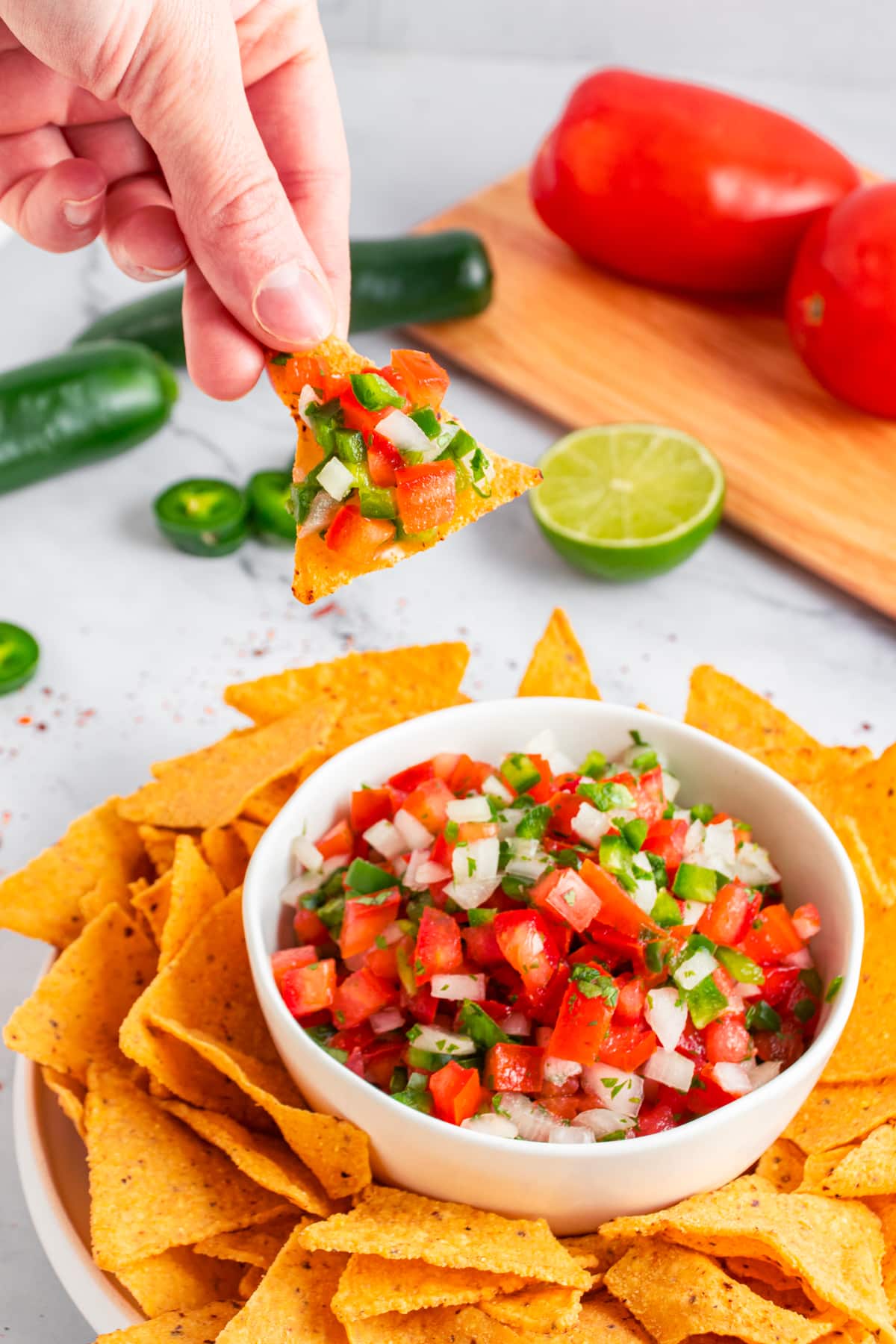 Taking a tortilla chip full of salsa. 