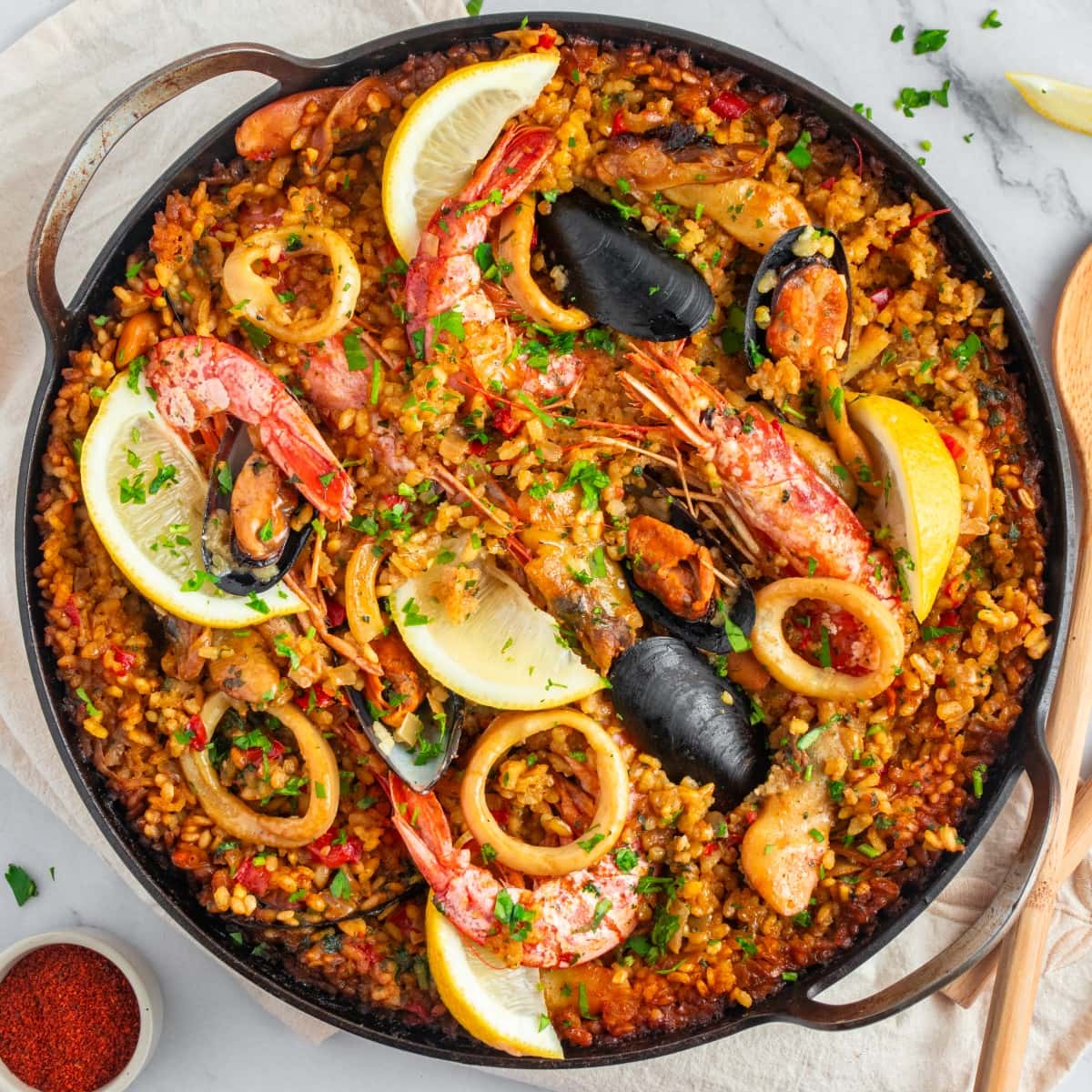 Square photo of seafood paella shot from overhead. 