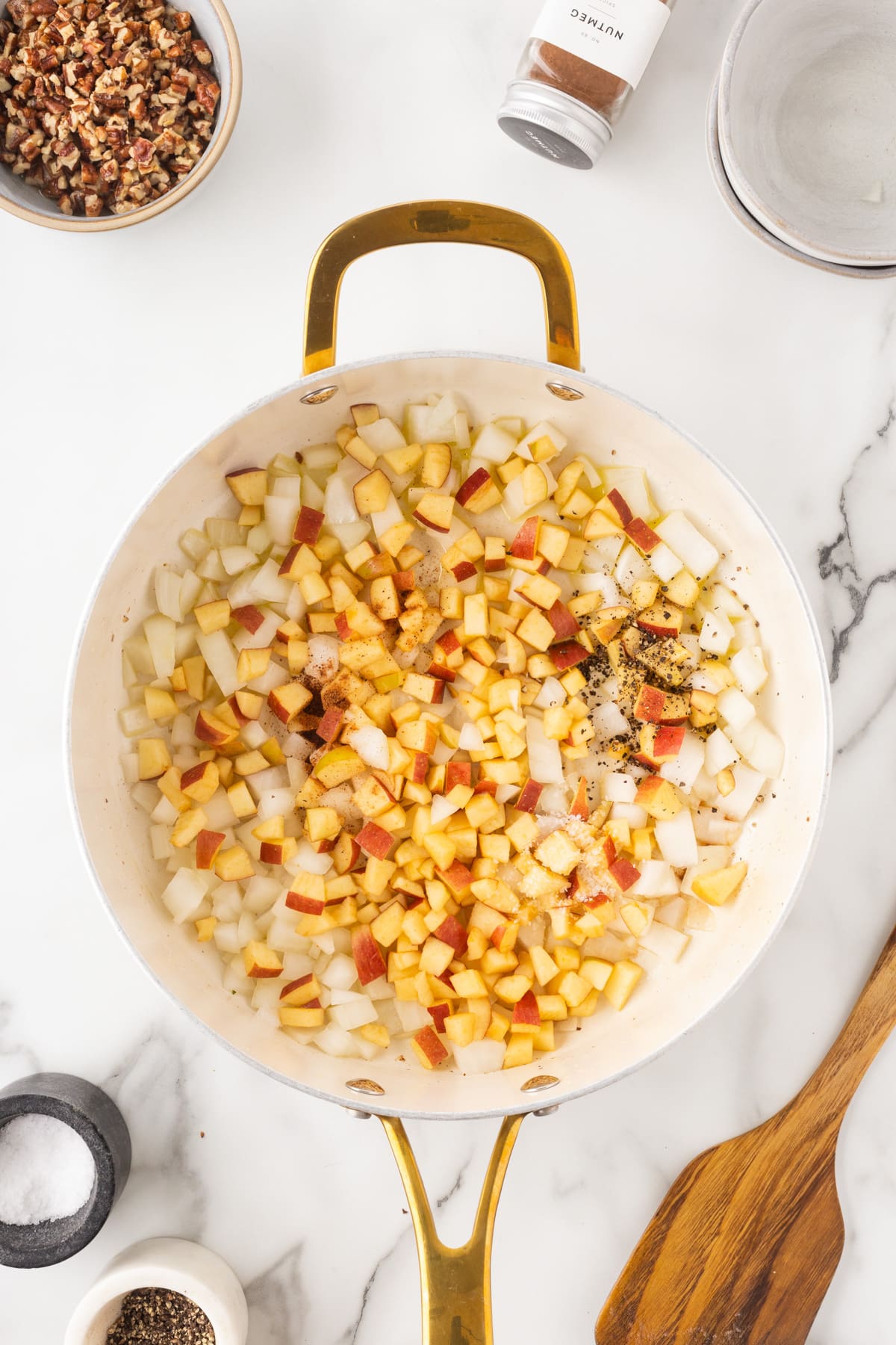 Adding salt, pepper and nutmeg to the apple mixture. 