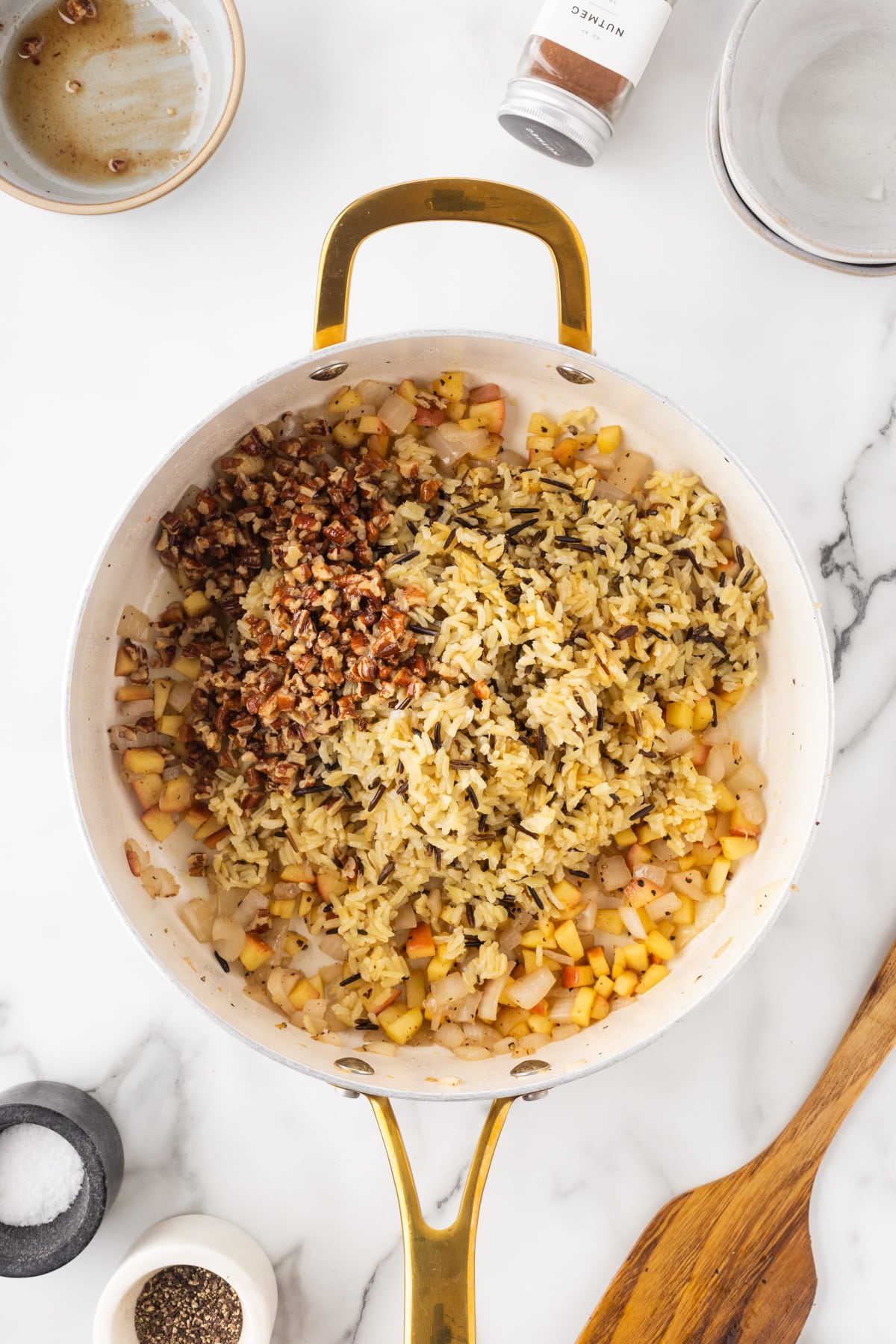 Adding rice and chopped pecans to the apple mixture. 