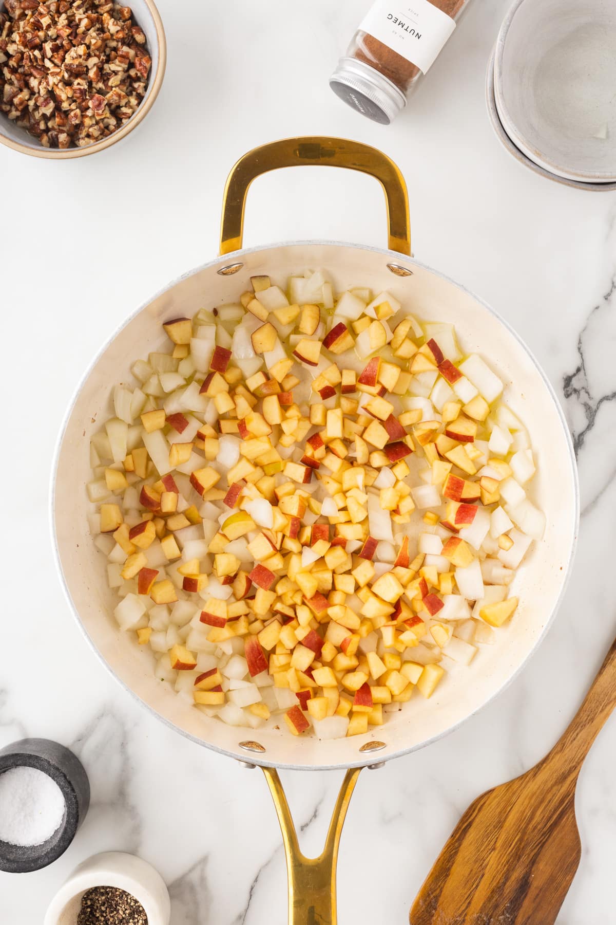 Cooking up apples and onions in a saute pan. 