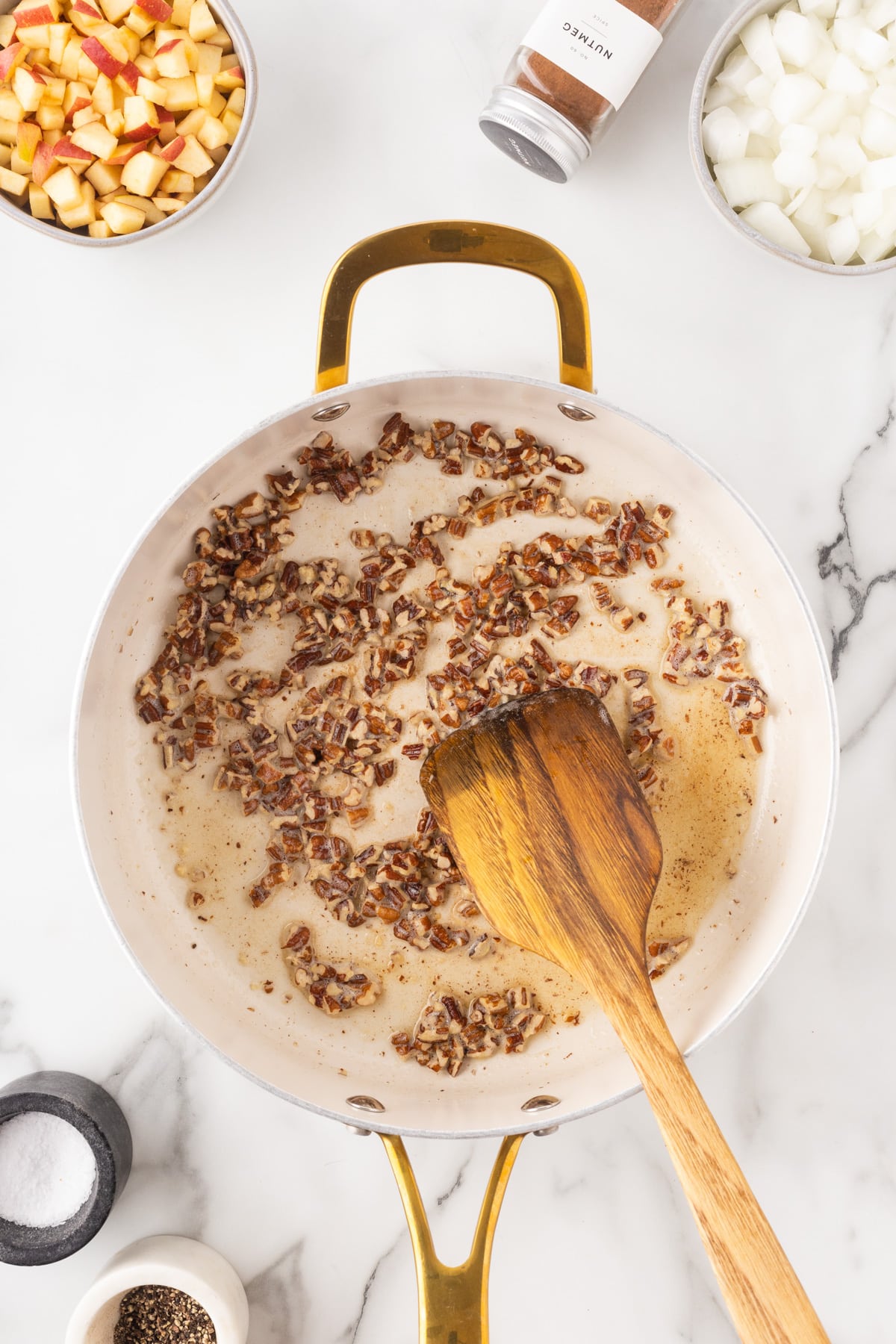 Cooking the chopped pecans in butter. 