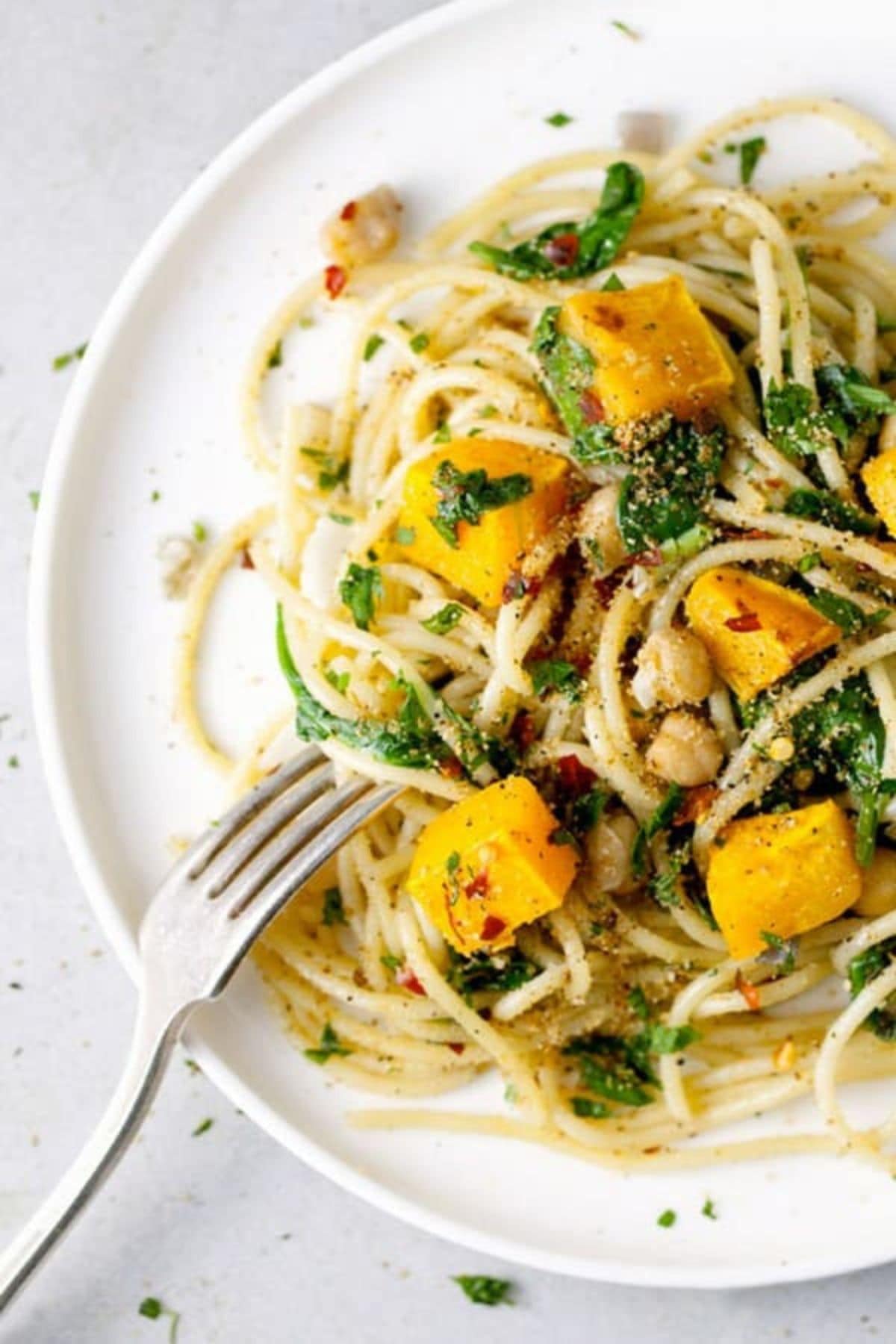 Plate full of butternut squash pasta with a fork.