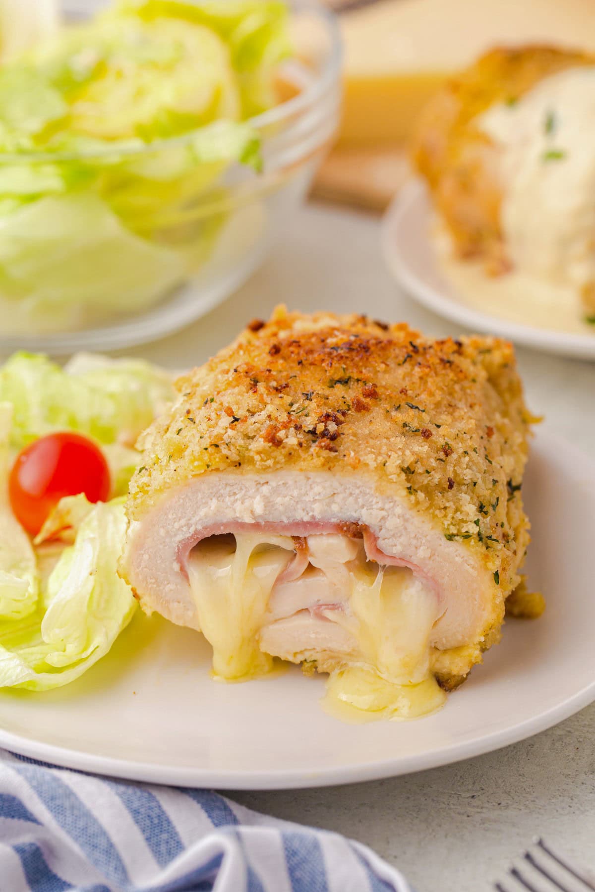 Showing cheese oozing out of the middle of a Chicken Cordon Bleu. 