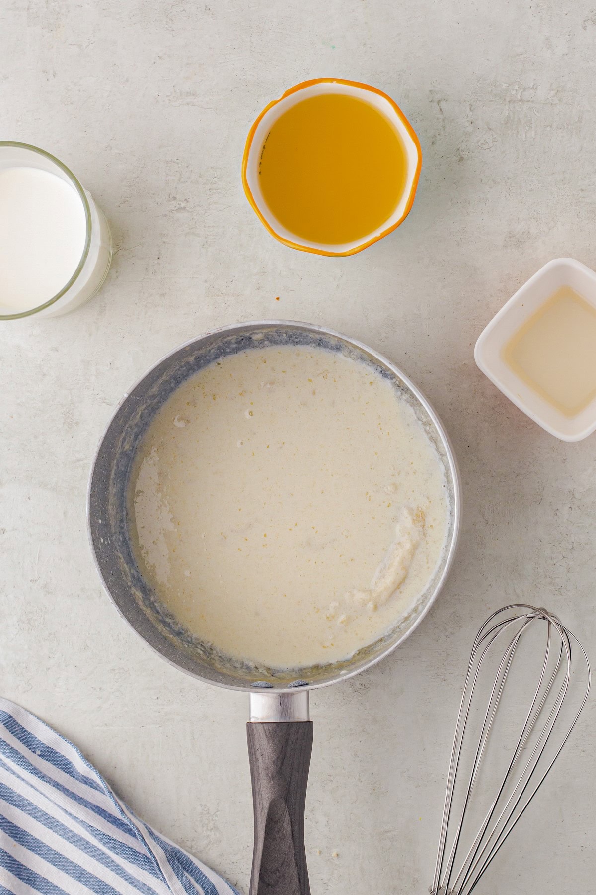 Adding liquid to the cream sauce. 