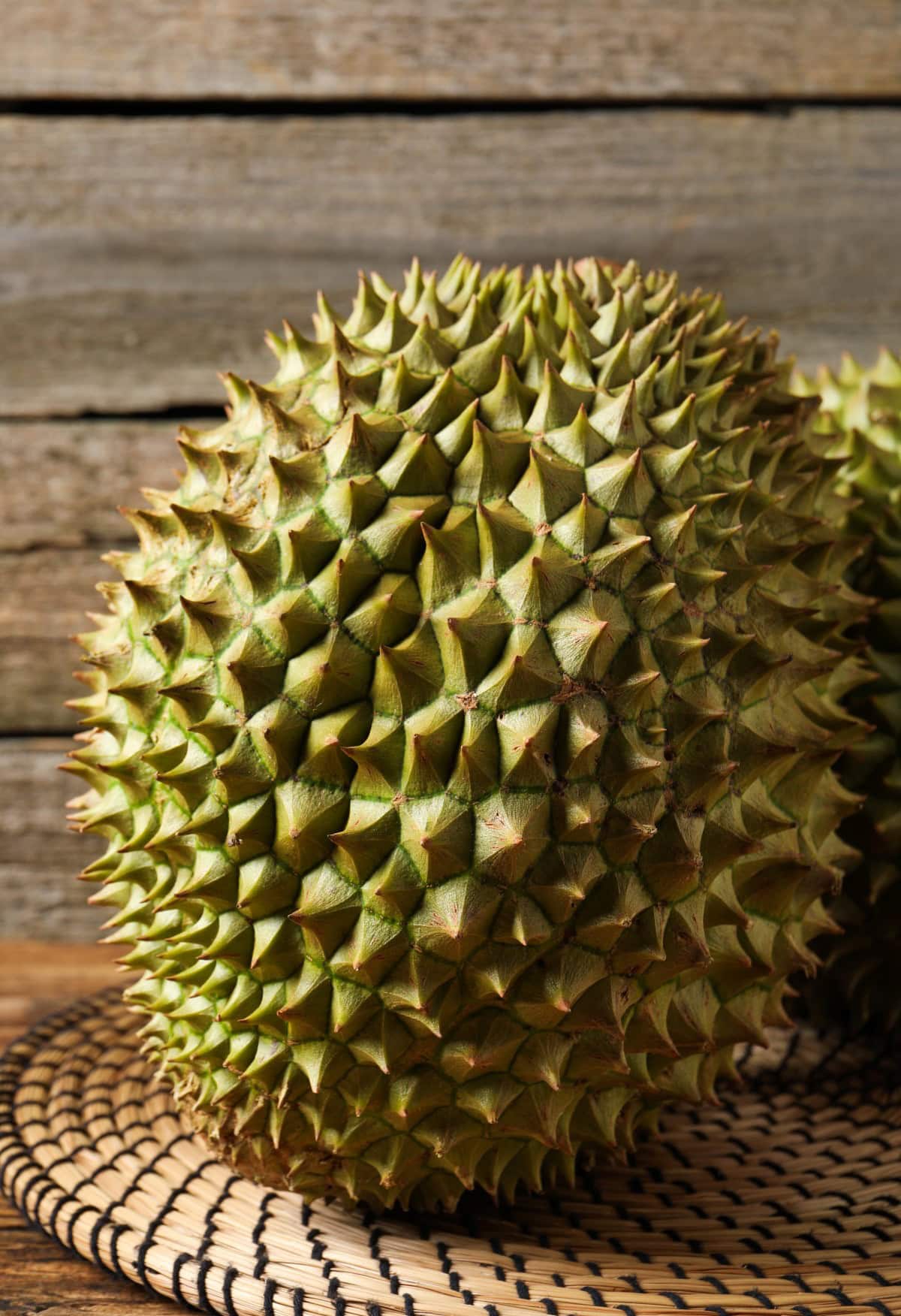 Ripe durians on wooden table, closeup view.