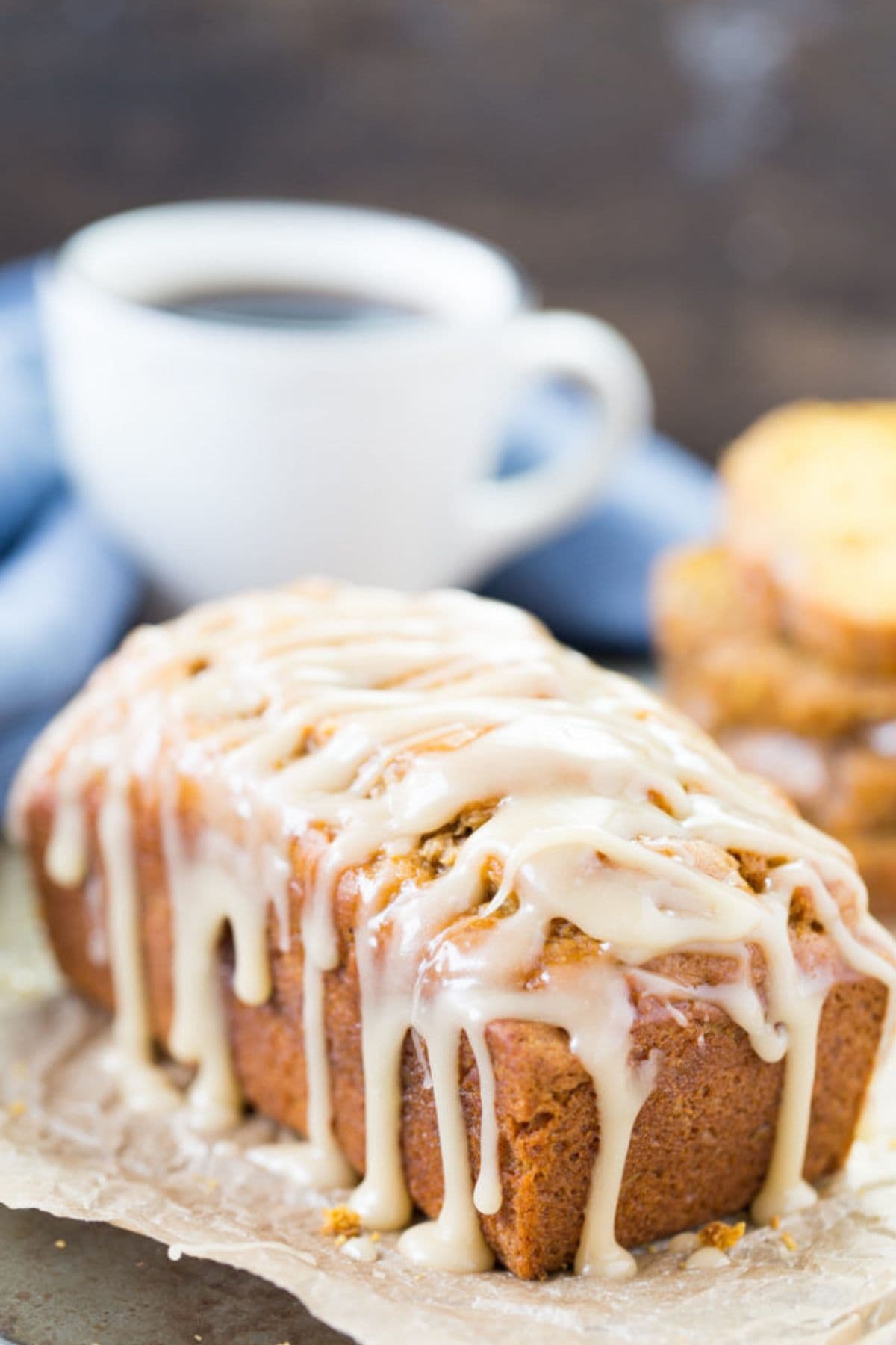 Whole pumpkin banana nut quick bread on a cutting board ready to serve.