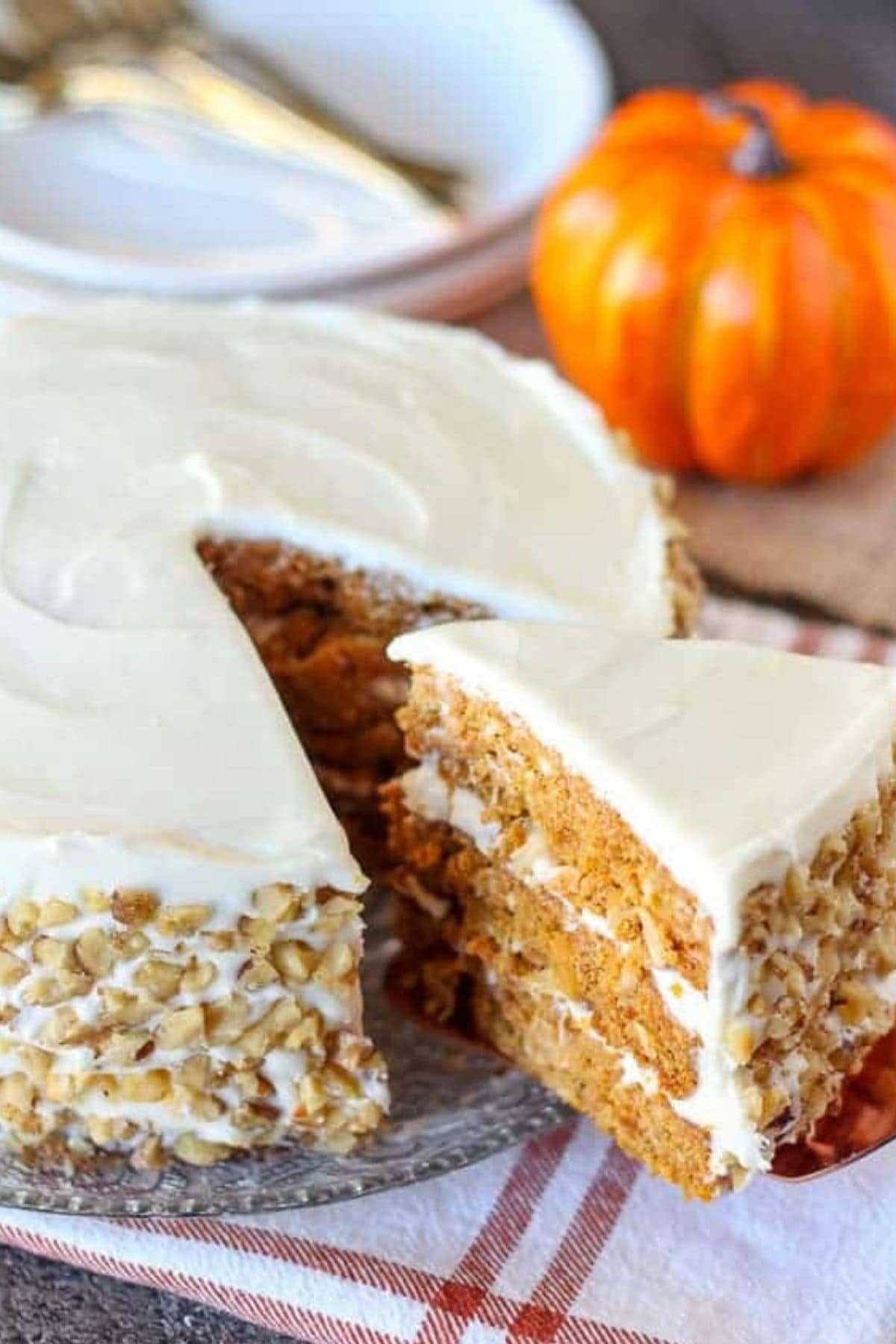 Slice of pumpkin carrot cake being removed from the cake with a cake server.