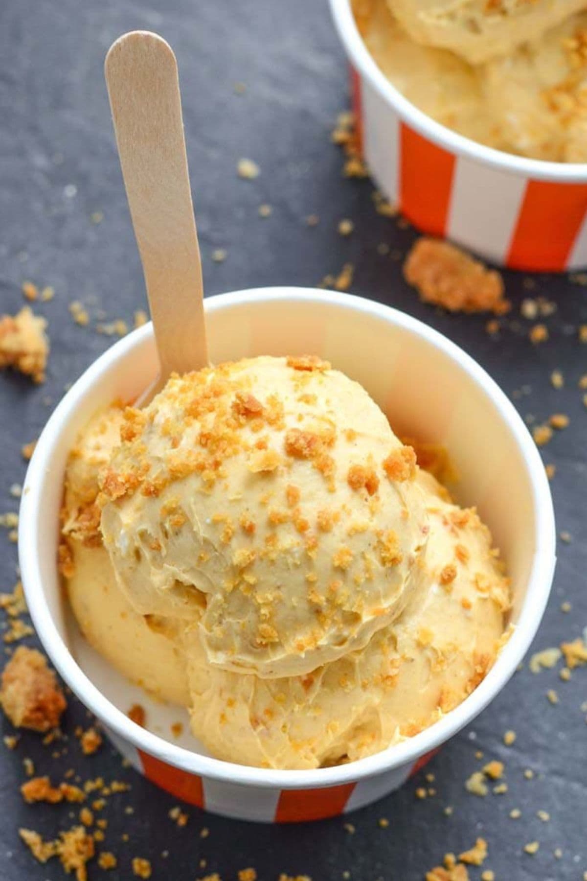 Small bowl filled with pumpkin cheesecake with a wooden spoon.