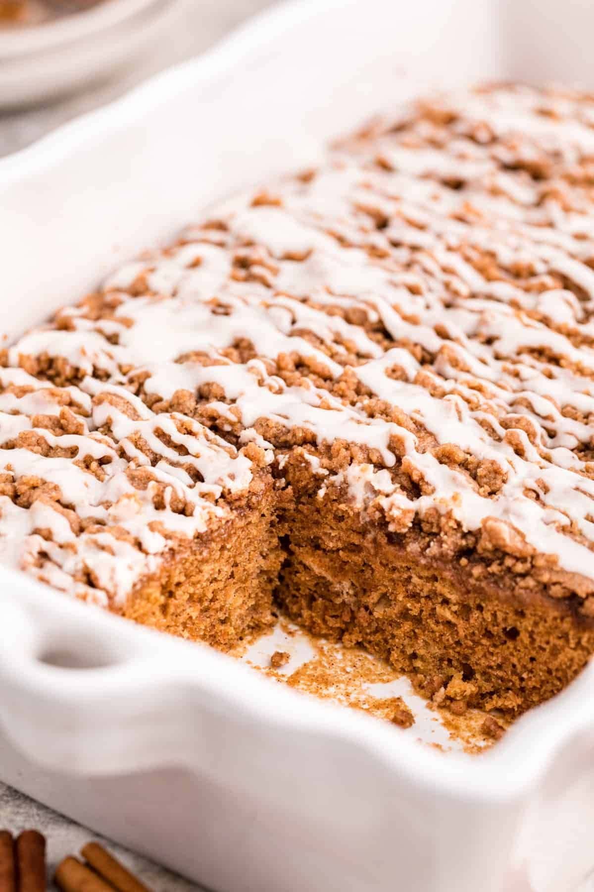 Pumpkin coffee cake in a casserole dish with a slice missing.