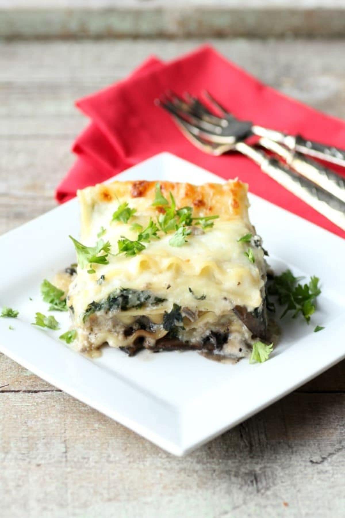 Slice of spinach mushroom lasagna on a small plate.