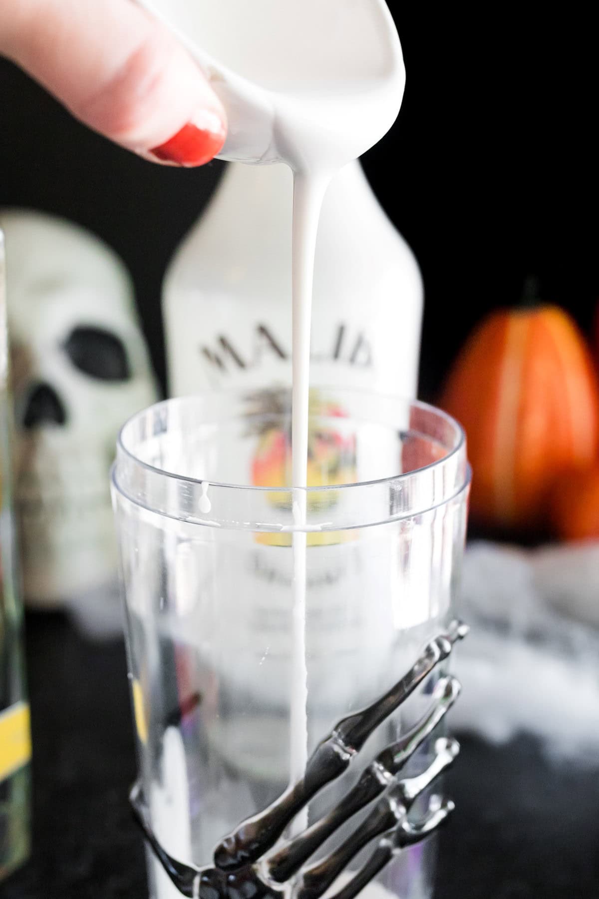 Pouring the coconut cream into a shaker. 