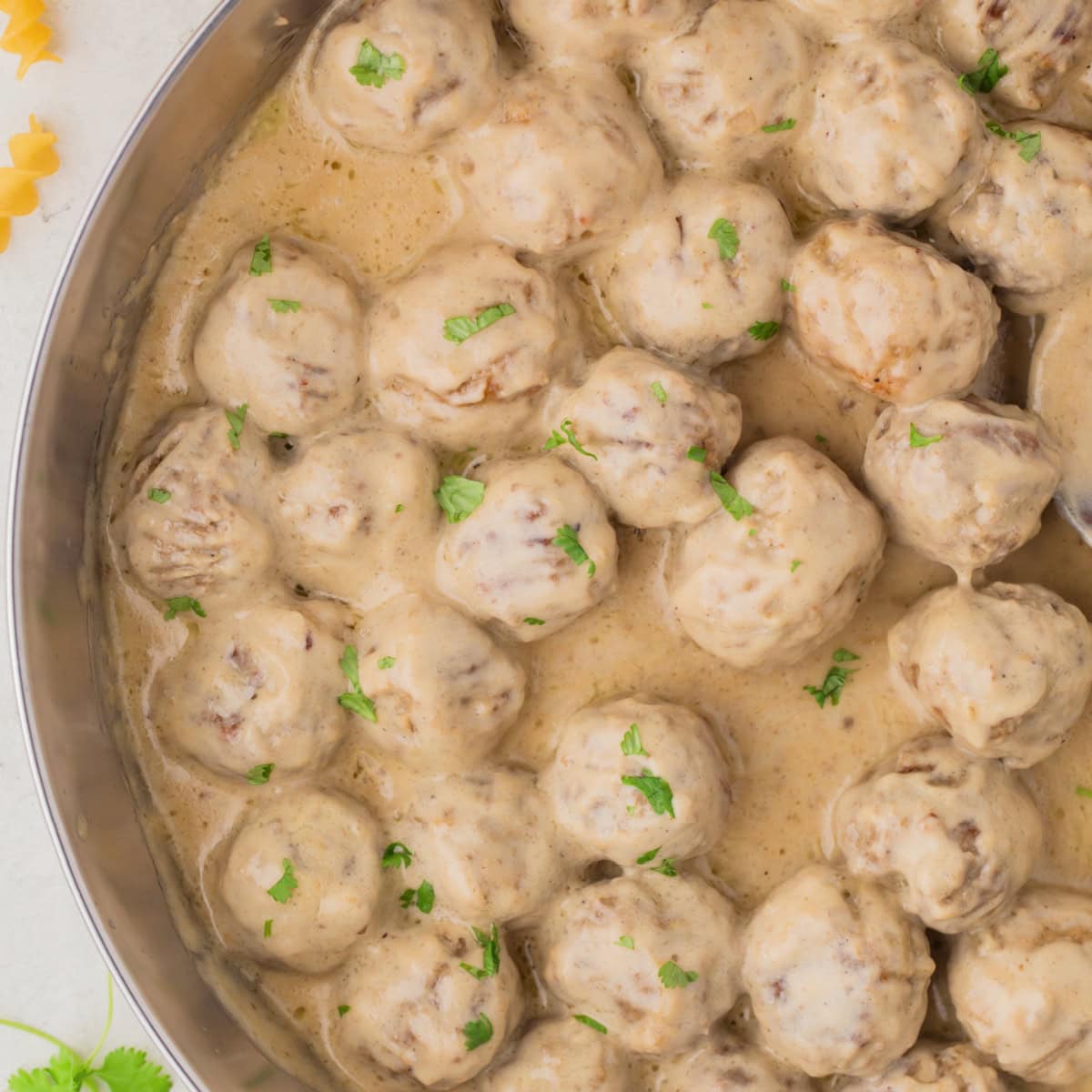 Square photo of Swedish meatballs in a pan. 