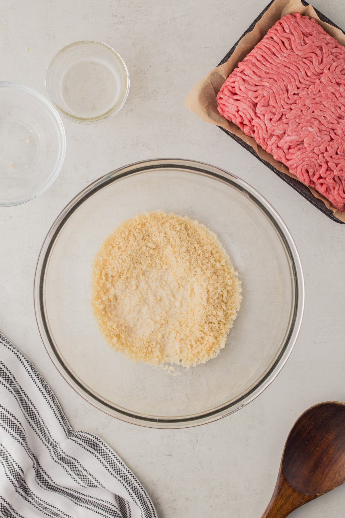 Bread crumbs and milk added to a bowl. 