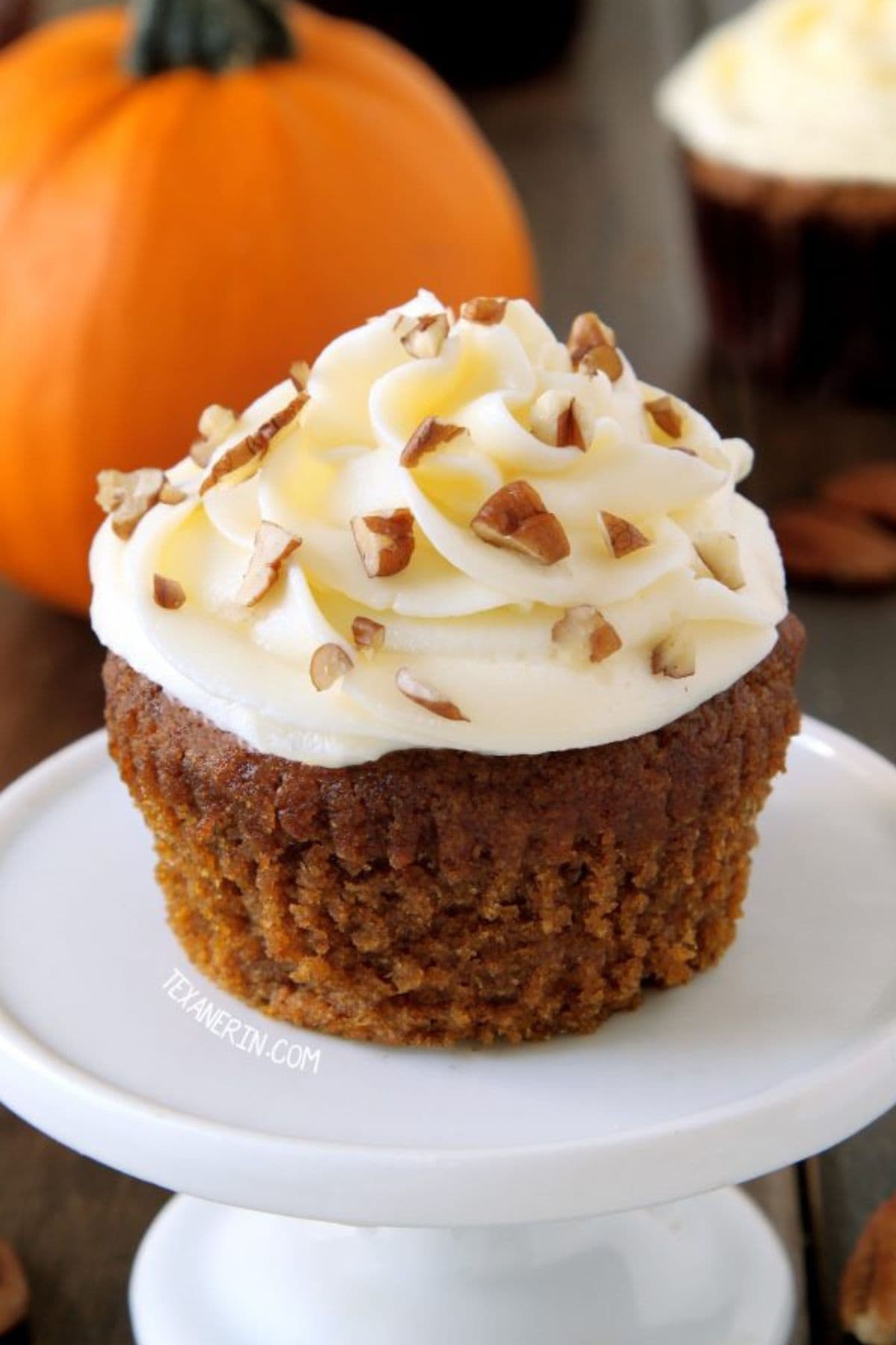 Pumpkin cupcake on a small cake stand.