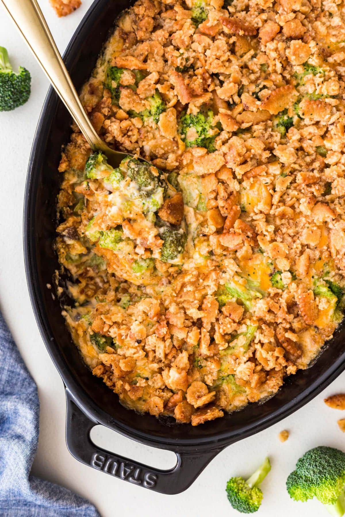 Cheesy broccoli casserole topped with crushed crackers in a casserole dish.