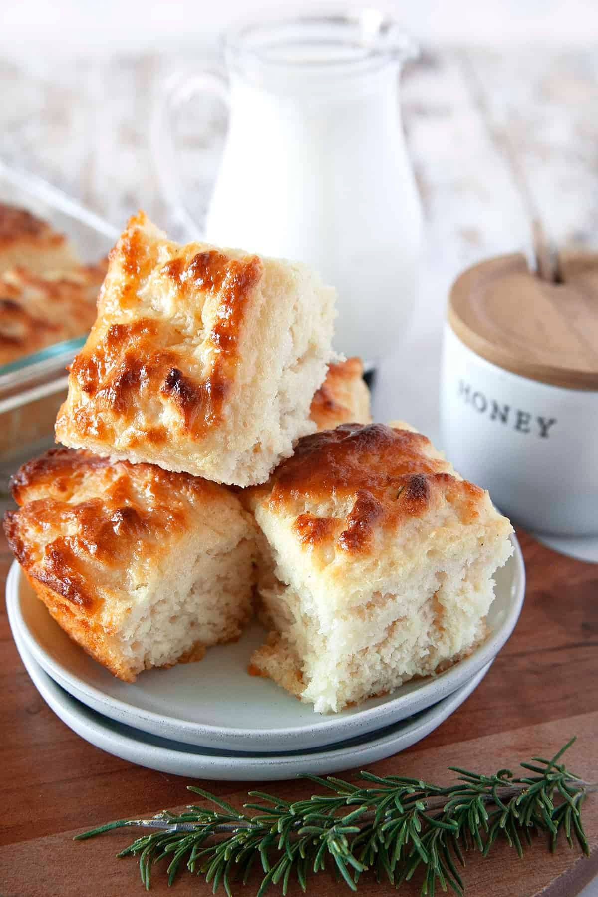 Four butter swim biscuits stacked on a small plate.