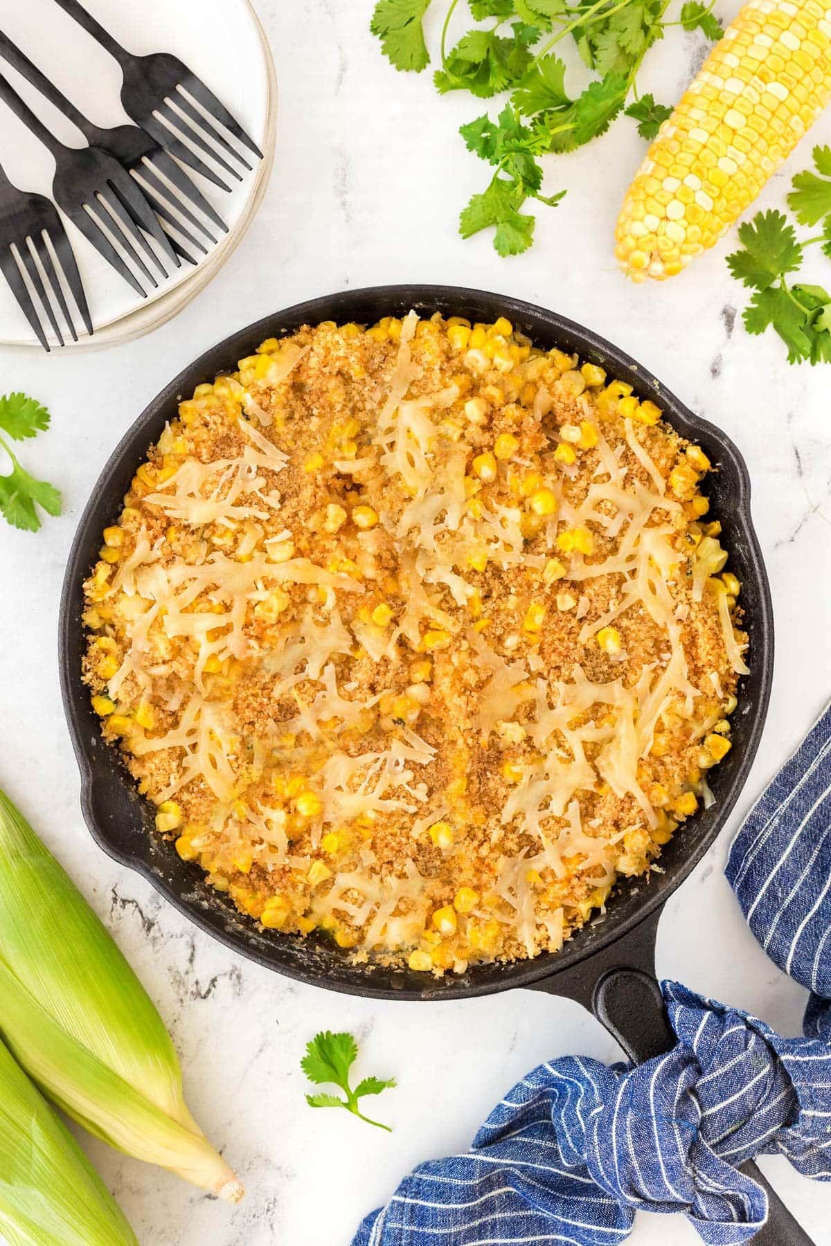 Cast iron skillet full of cheesy corn casserole ready to serve.