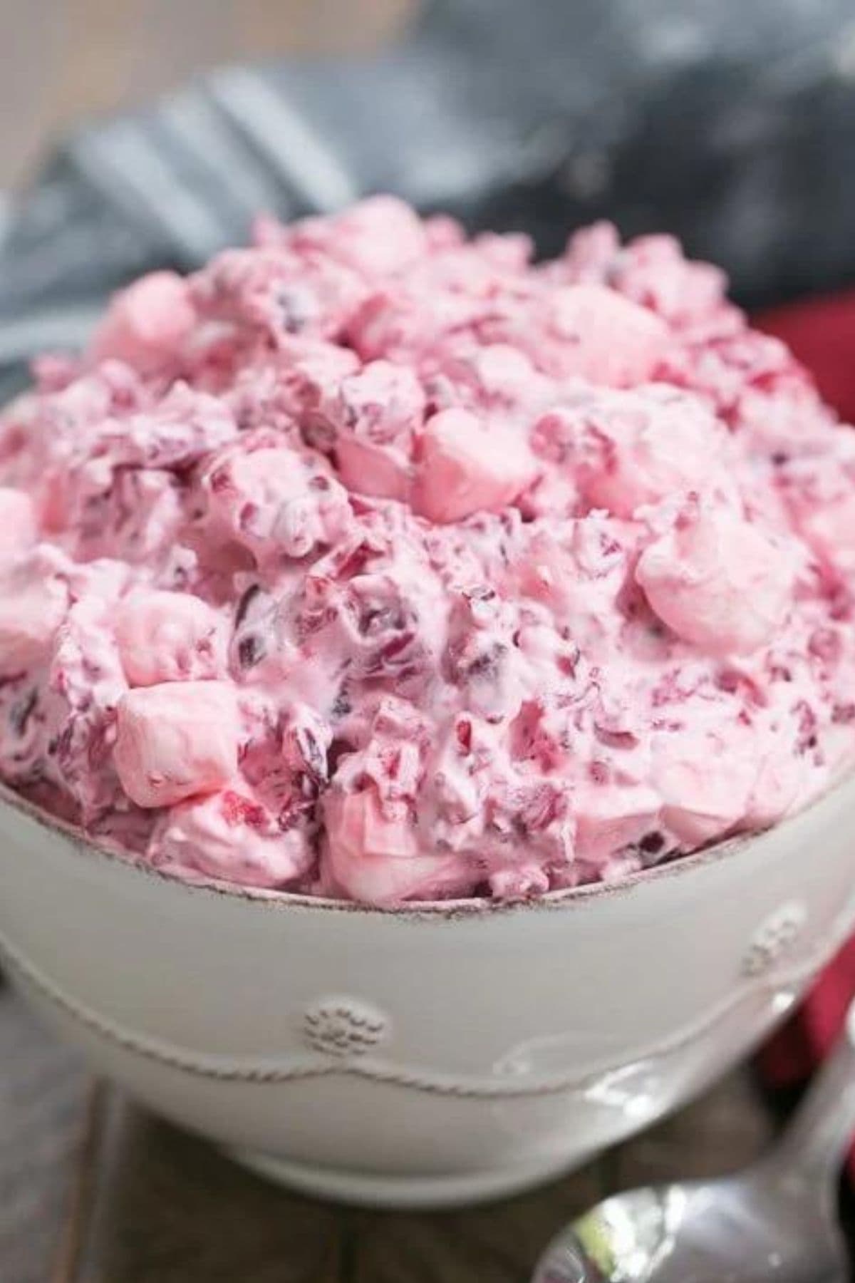 Serving bowl filled to the brim with cranberry fluff salad.