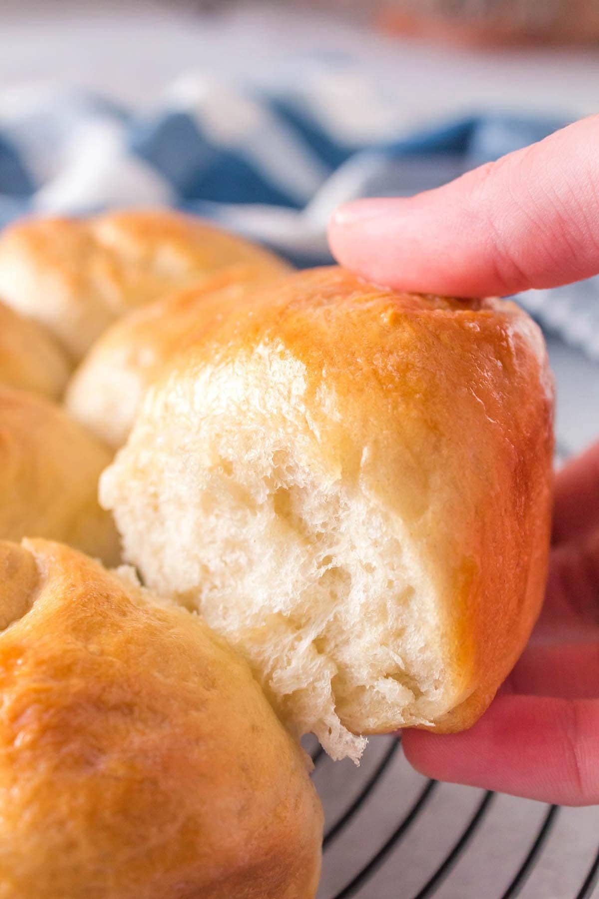 Easy yeast roll being removed from a wire cooling rack.