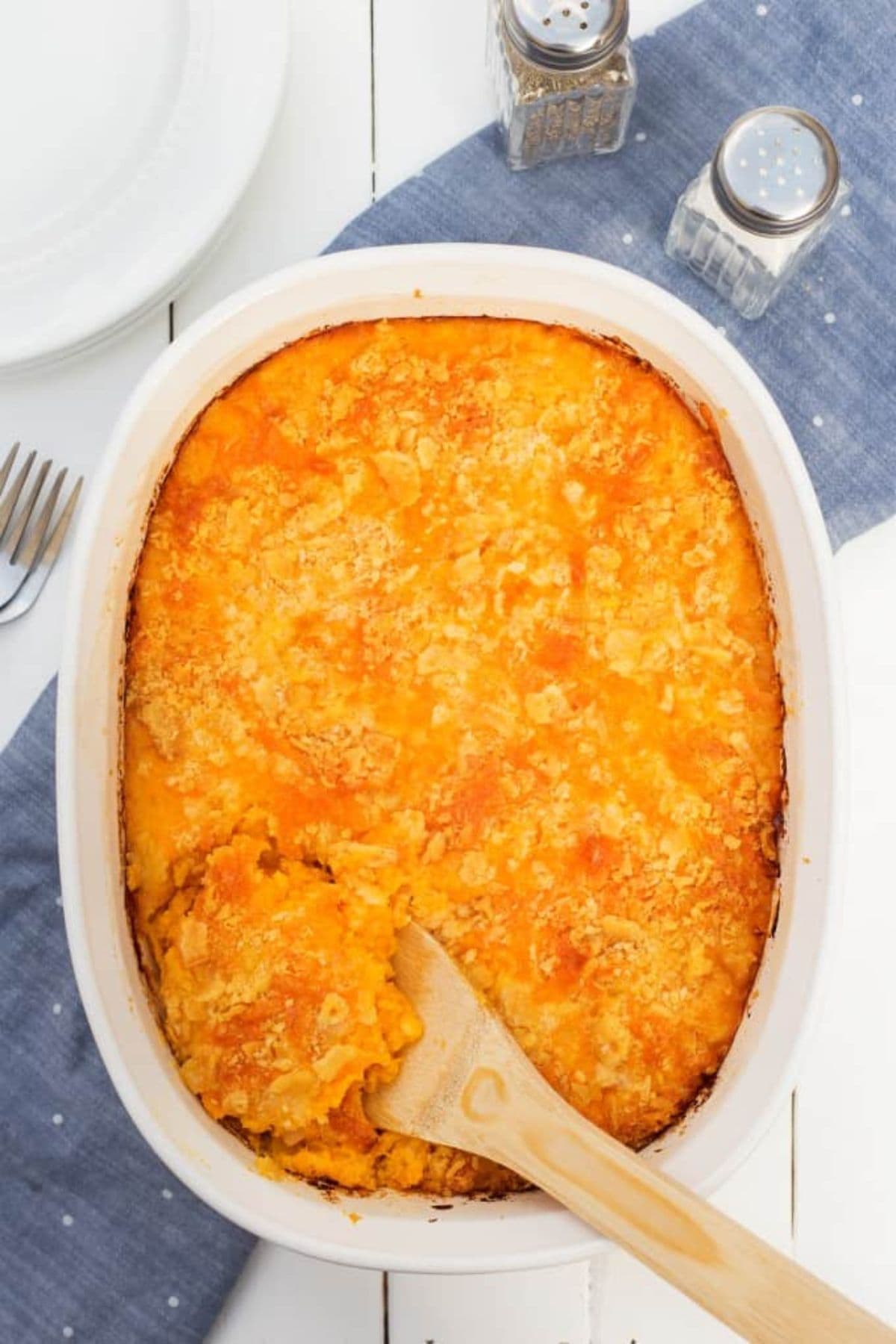 Casserole dish filled with old fashioned squash casserole on a table ready to serve.