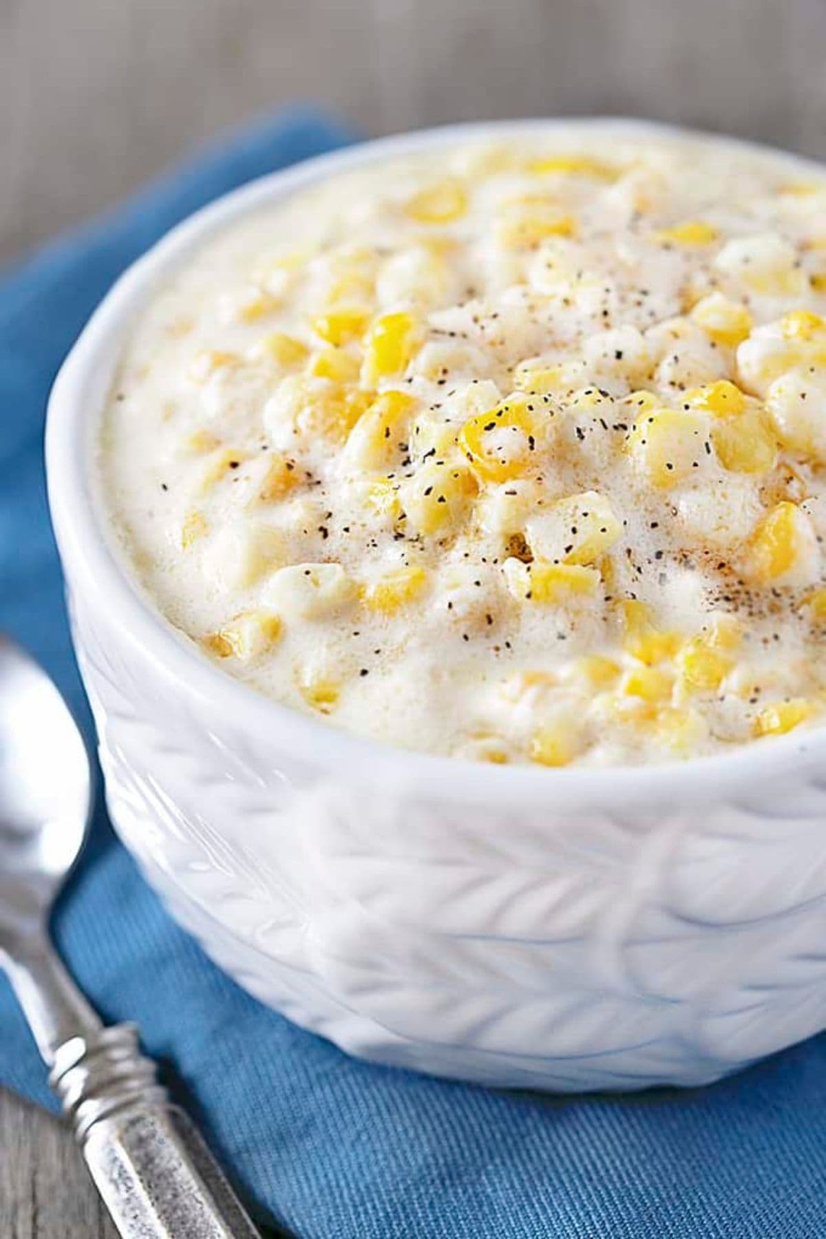 Bowl full of slow cooker creamed corn on a table.