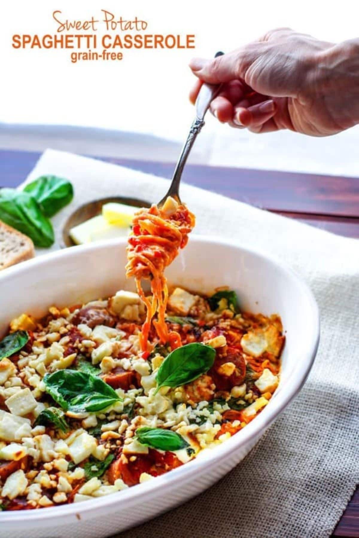 Serving dish of sweet potato spaghetti casserole with a fork removing a bite.