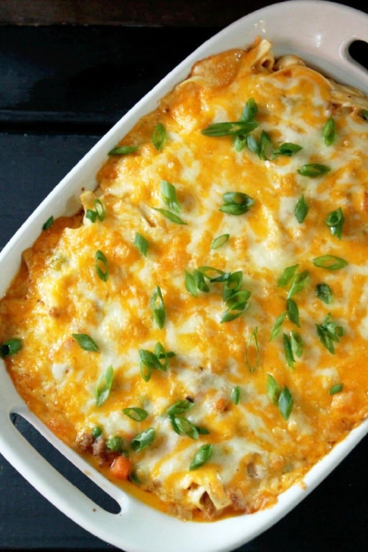 Turkey noodle casserole in a casserole dish garnished with sliced green onions.