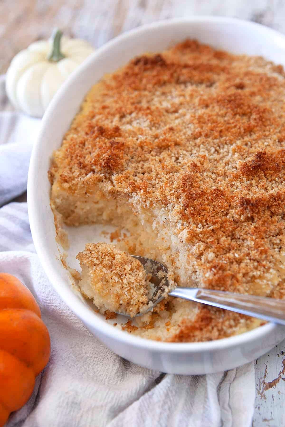 Turnip puff in a casserole dish with a serving missing.