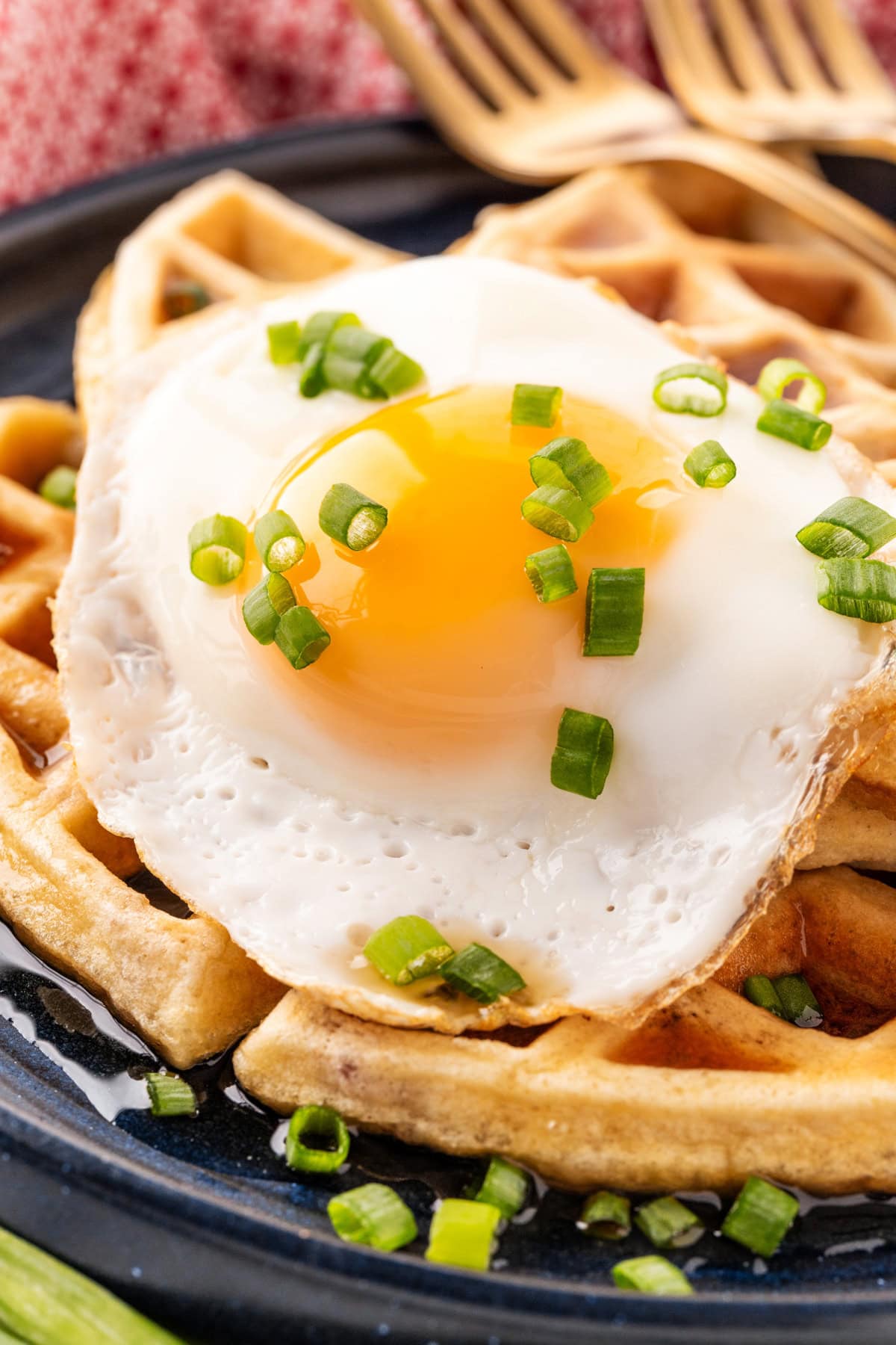 Close-up of a fried egg on top of waffles. 