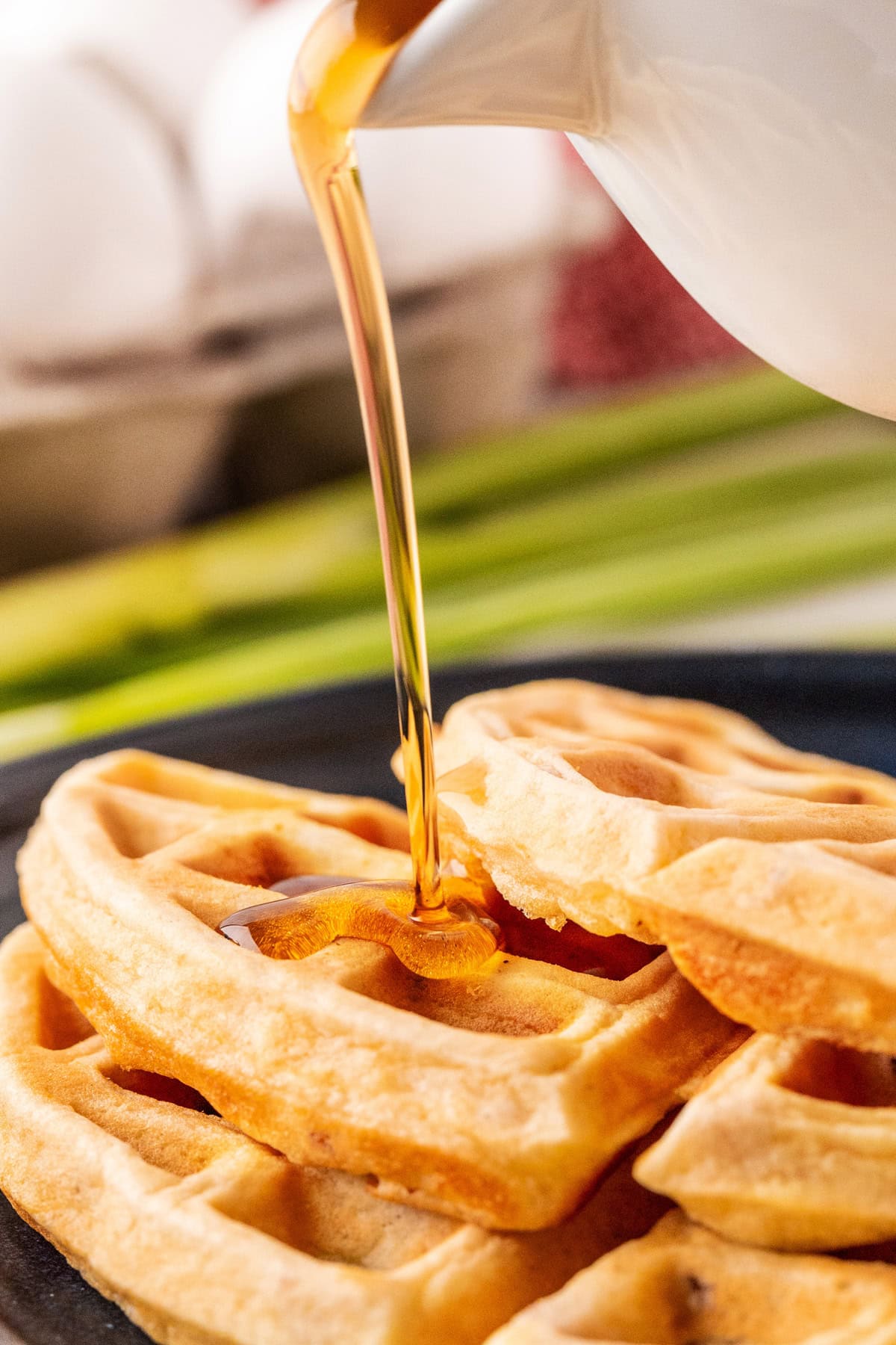 Pouring maple syrup on waffles. 