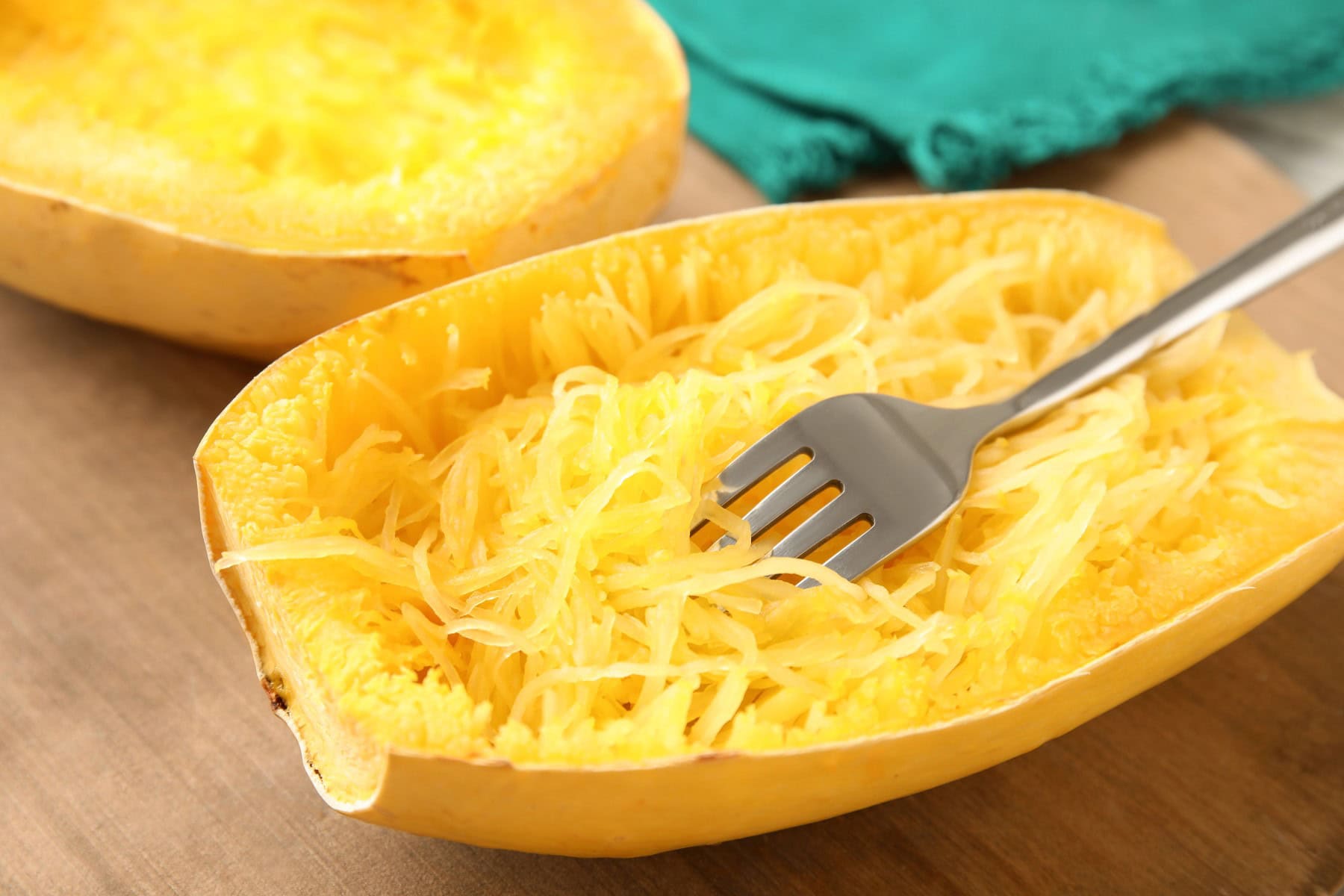 Cooked spaghetti squash and fork on table.