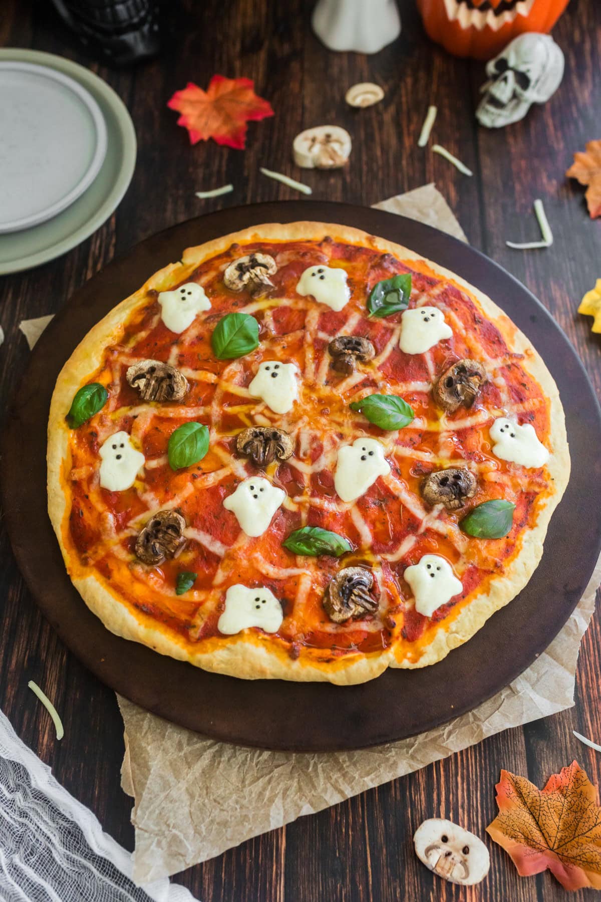 Halloween pizza with ghosts, spider web and skull mushrooms. 