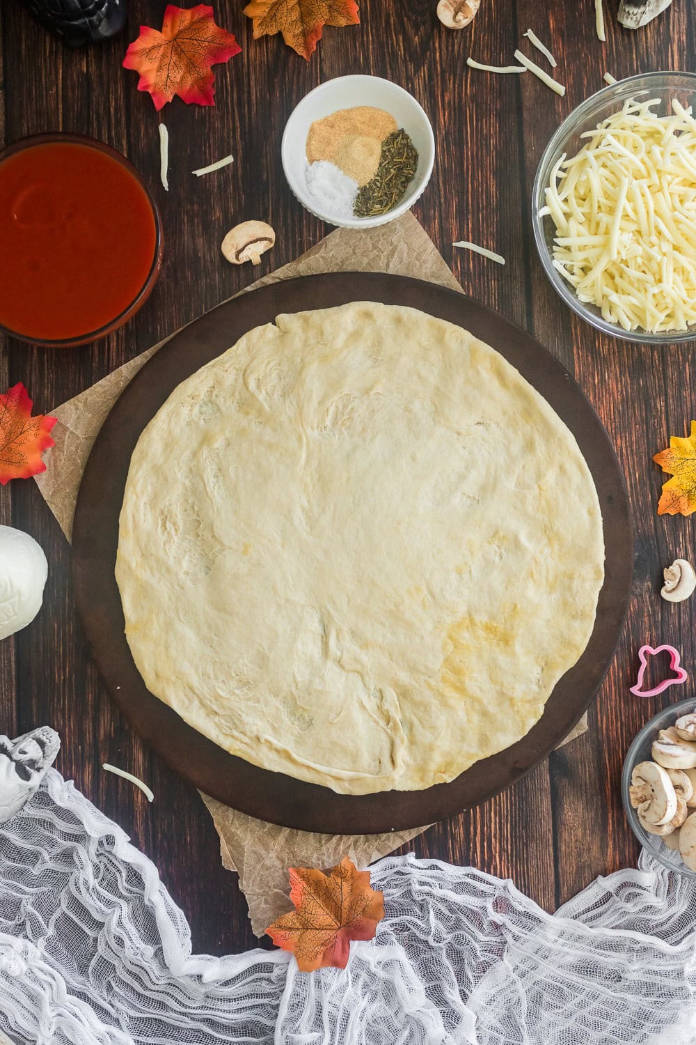 Pizza dough rolled out onto a pizza stone. 