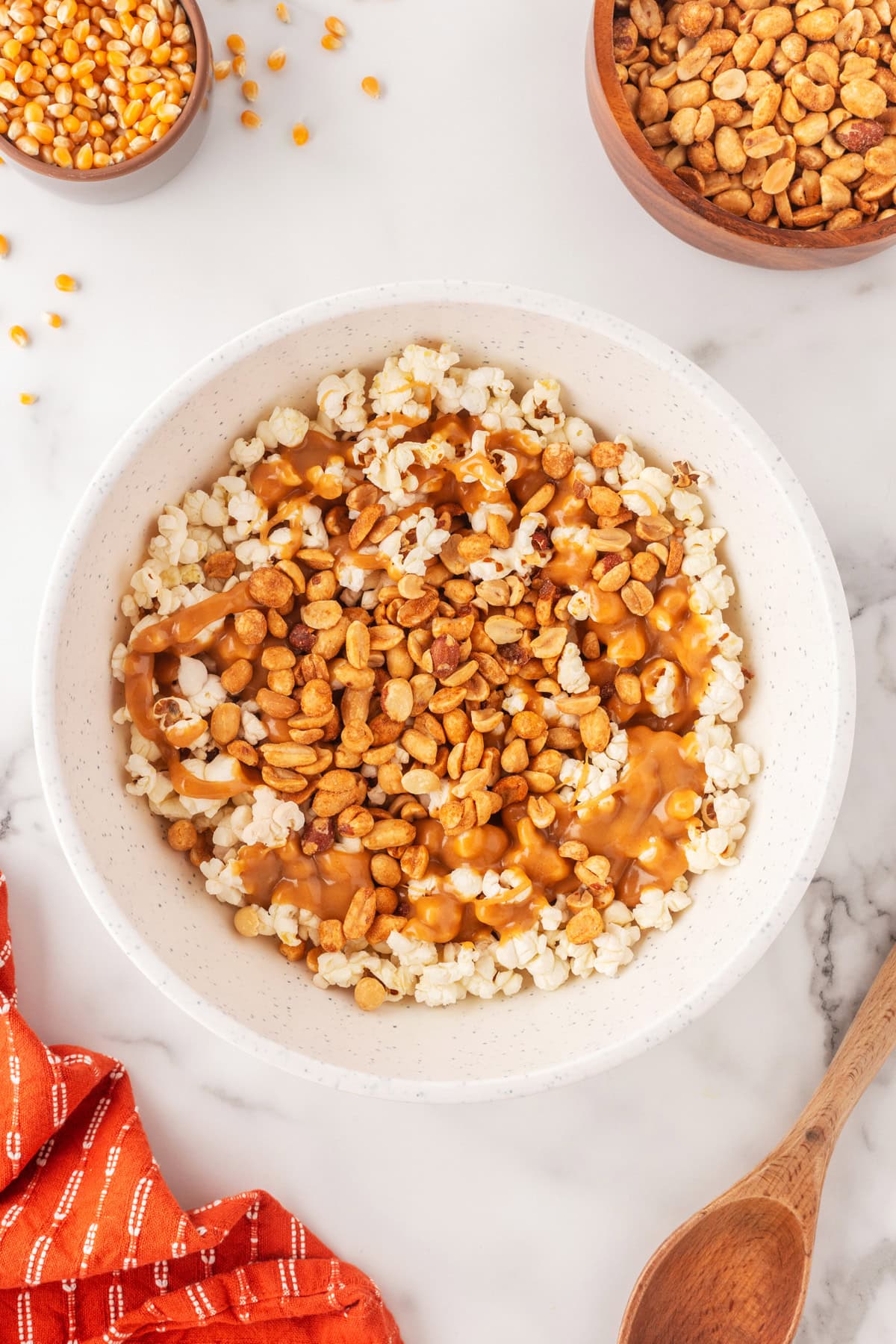 Pouring the peanut mixture on the popcorn. 