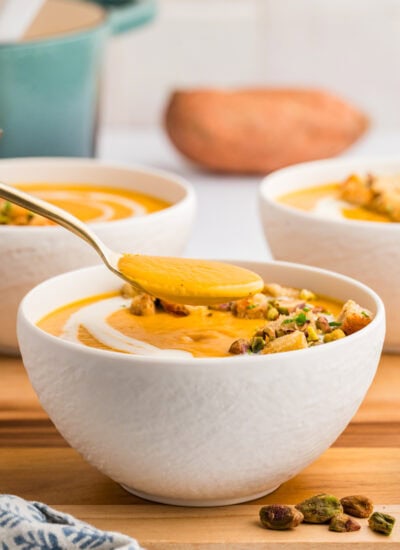 Taking a spoonful of soup from a bowl.