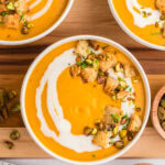 Overhead of three bowls of sweet potato soup.