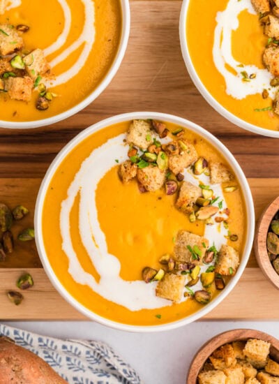 Overhead of three bowls of sweet potato soup.