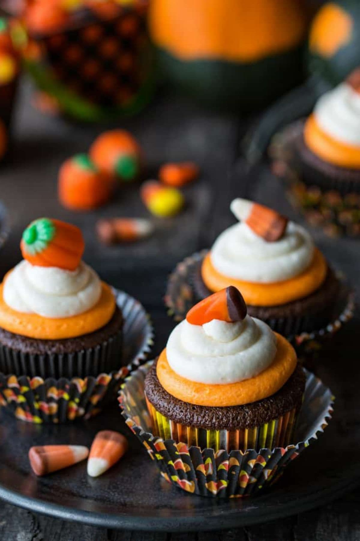 Three easy chocolate cupcakes with candy corn layered frosting on a serving platter.