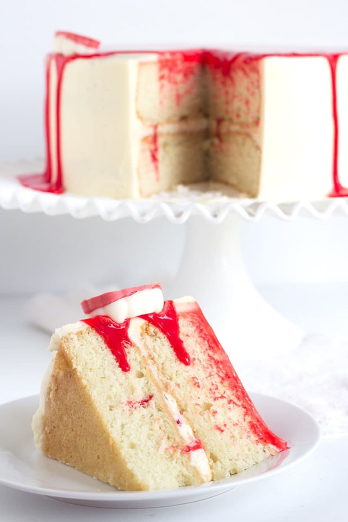 Slice of Goosebumps cake on a small plate, with the full cake behind it.