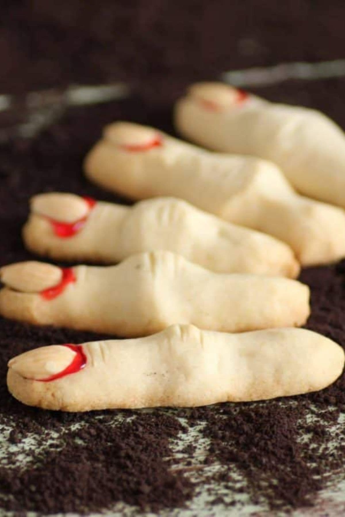 Witch finger cookies on a dark background.