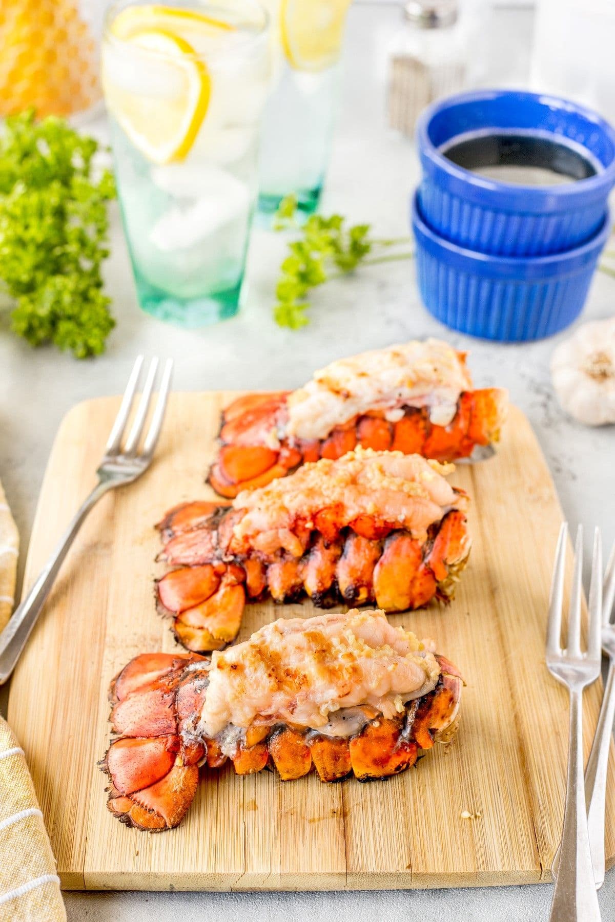 Lobster tails on cutting board.