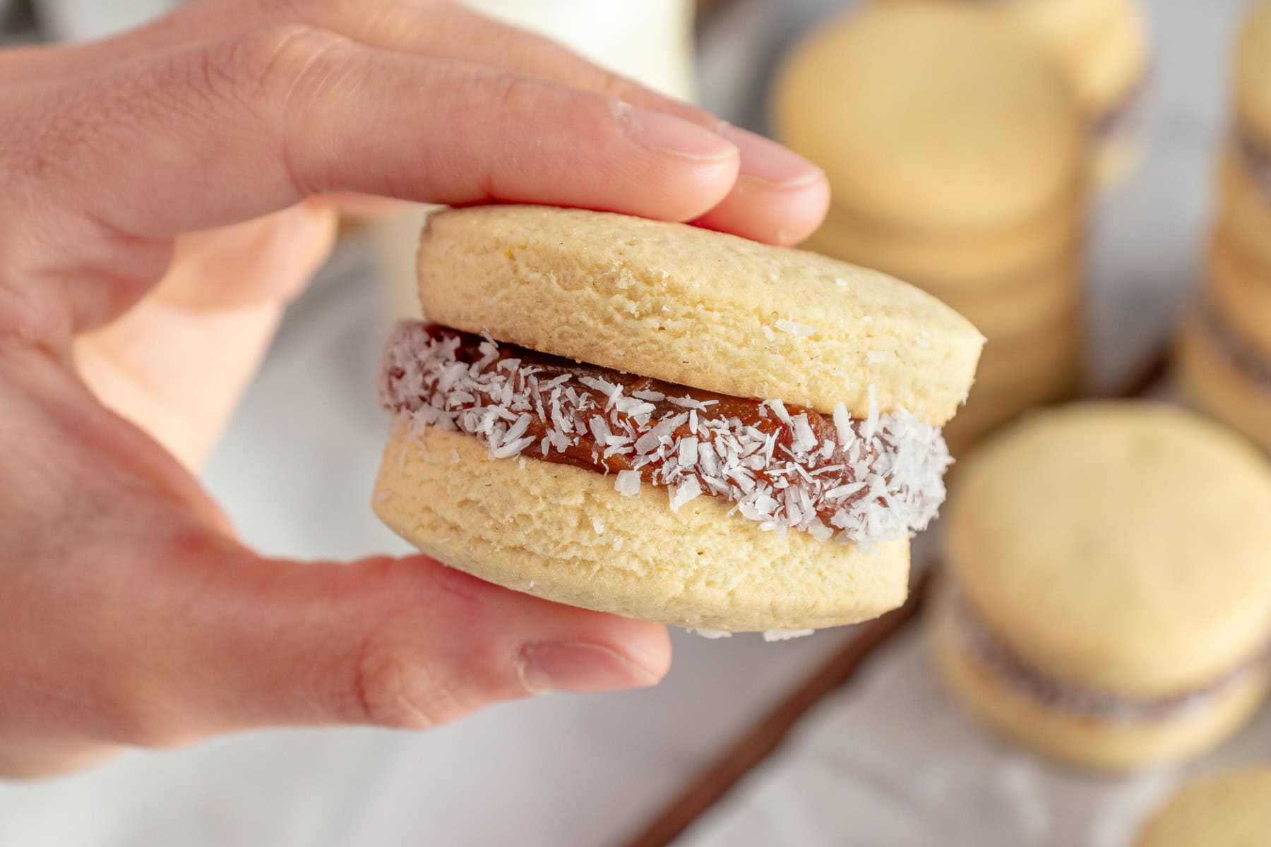 Holding an alfajores. 