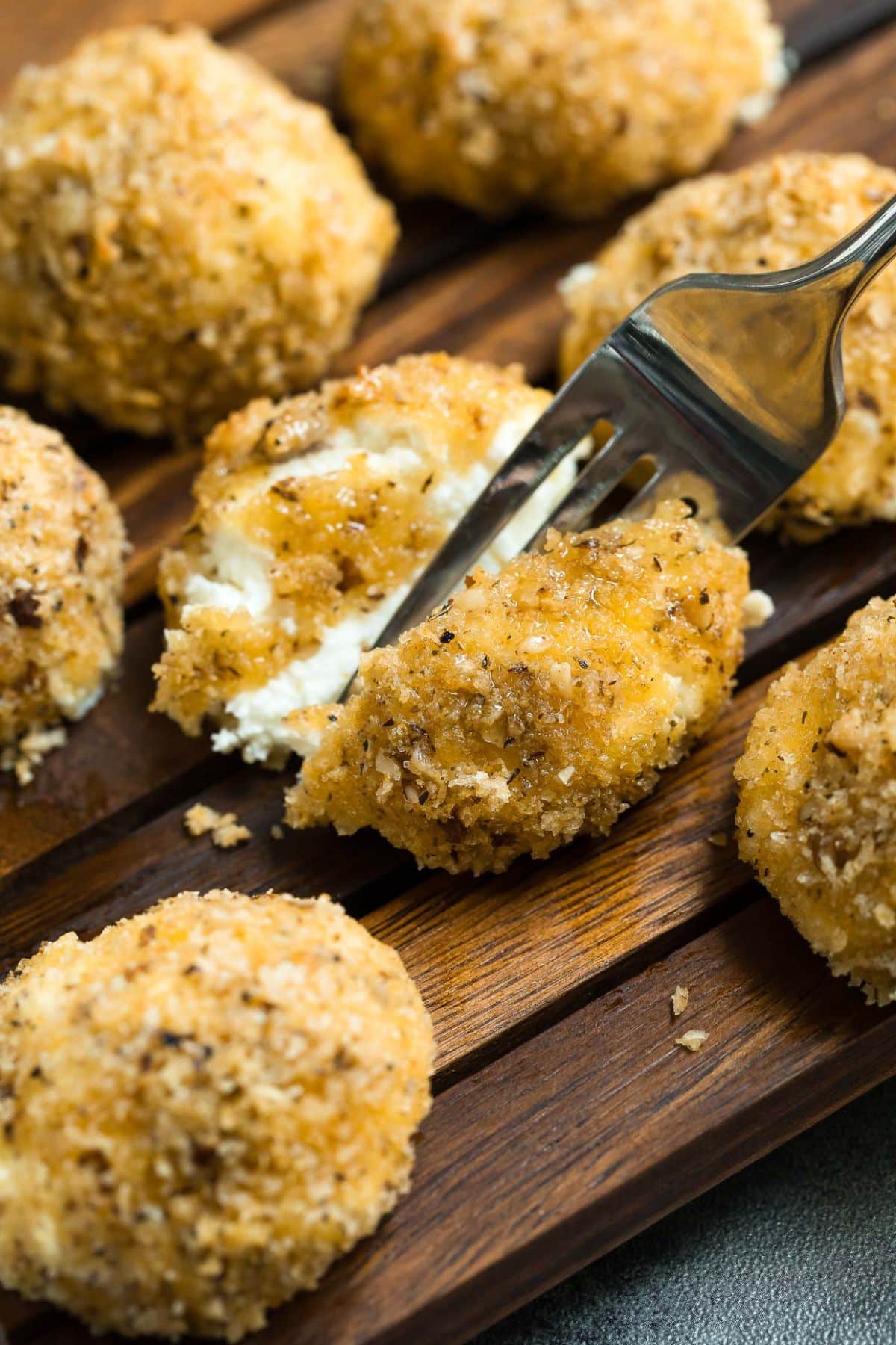 Goat cheese balls on a cutting board.