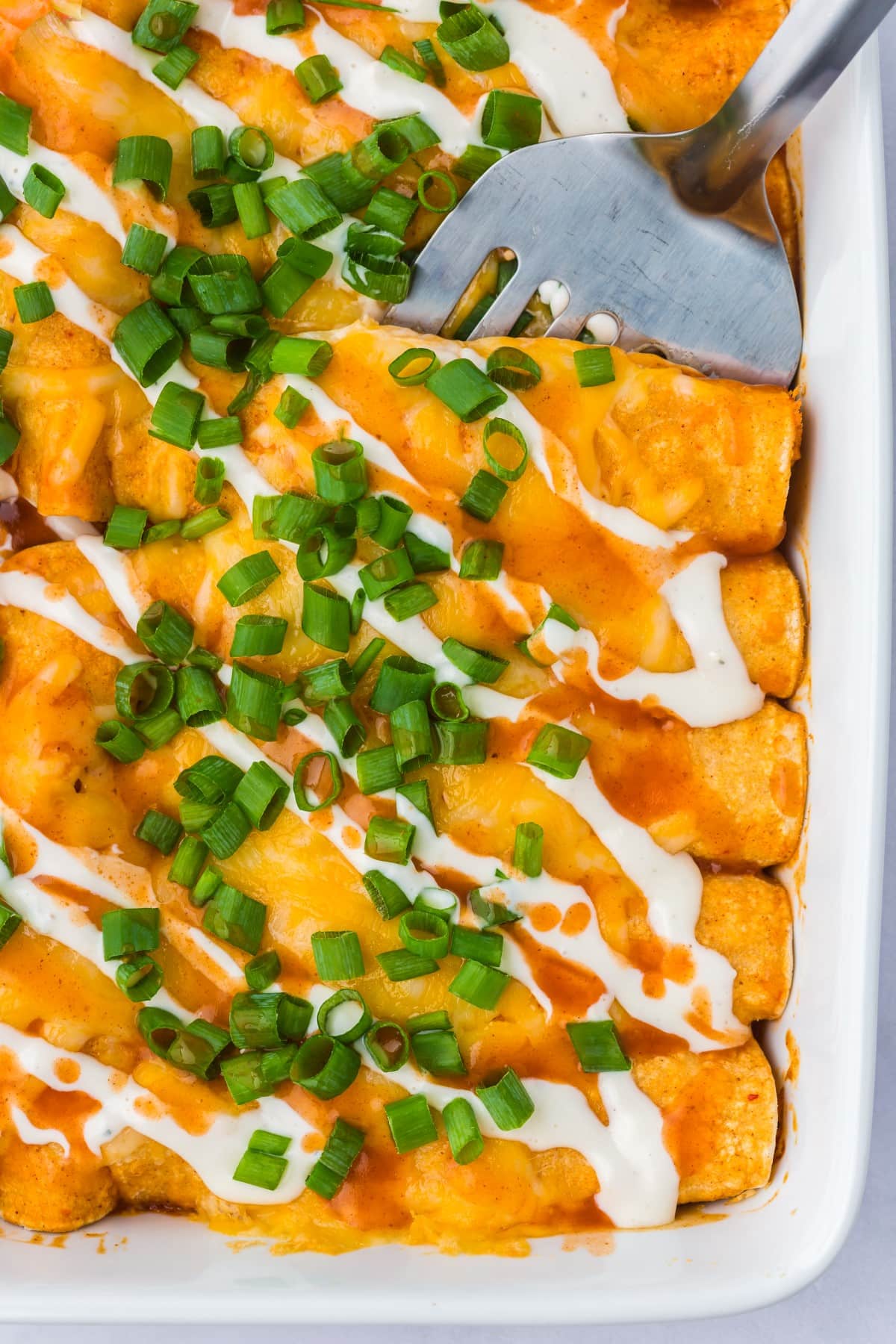 Taking a Buffalo Chicken Enchilada from the pan. 