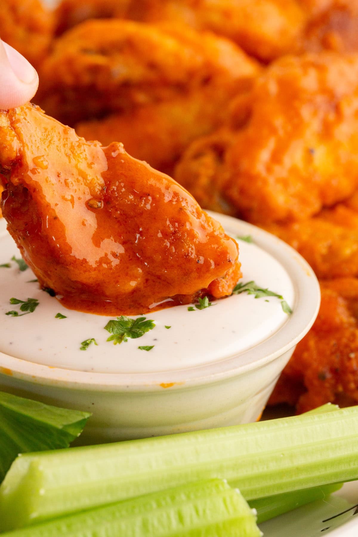 Buffalo Hot Wing being dipped in ranch dressing. 