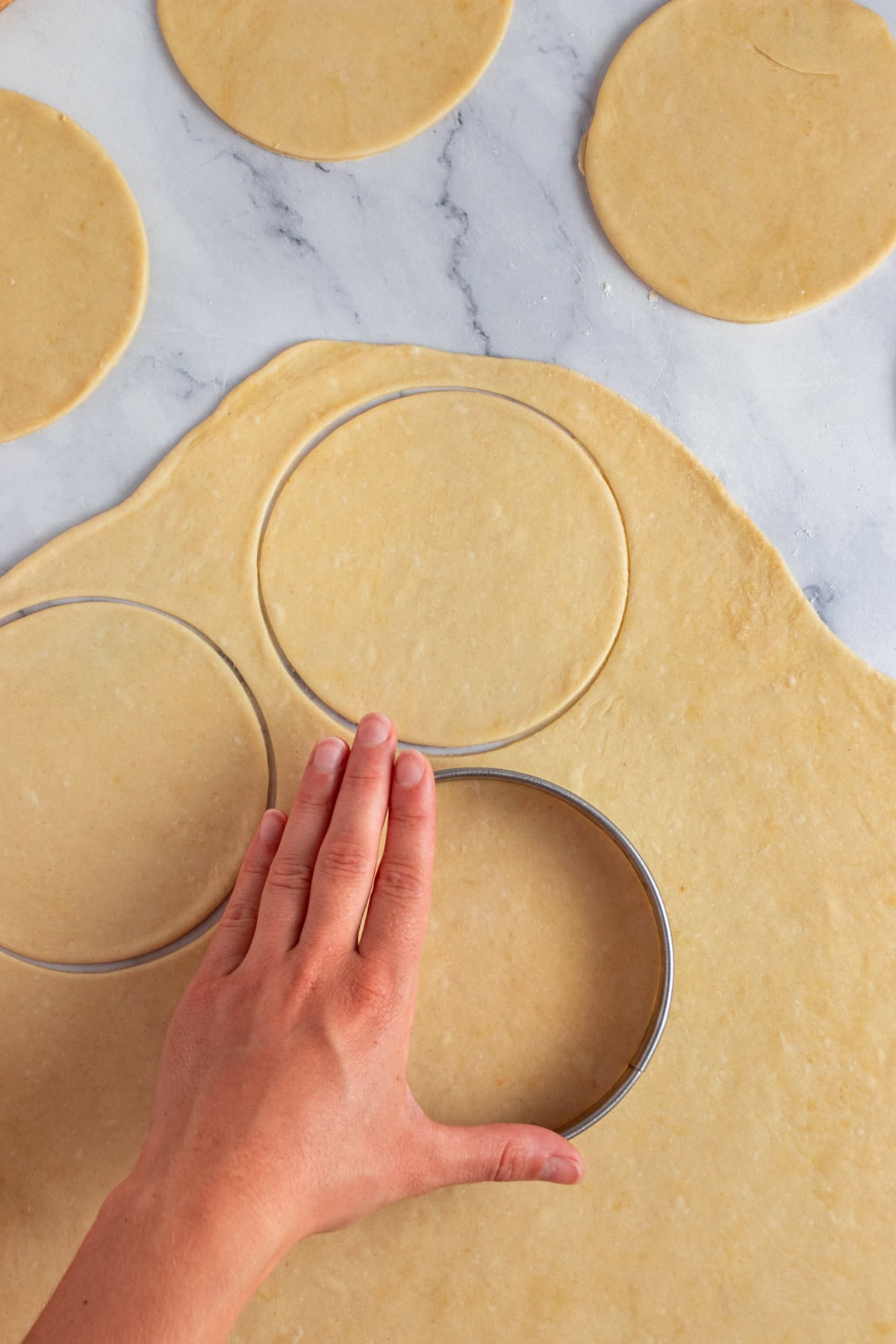 Cutting empanadas circles out.