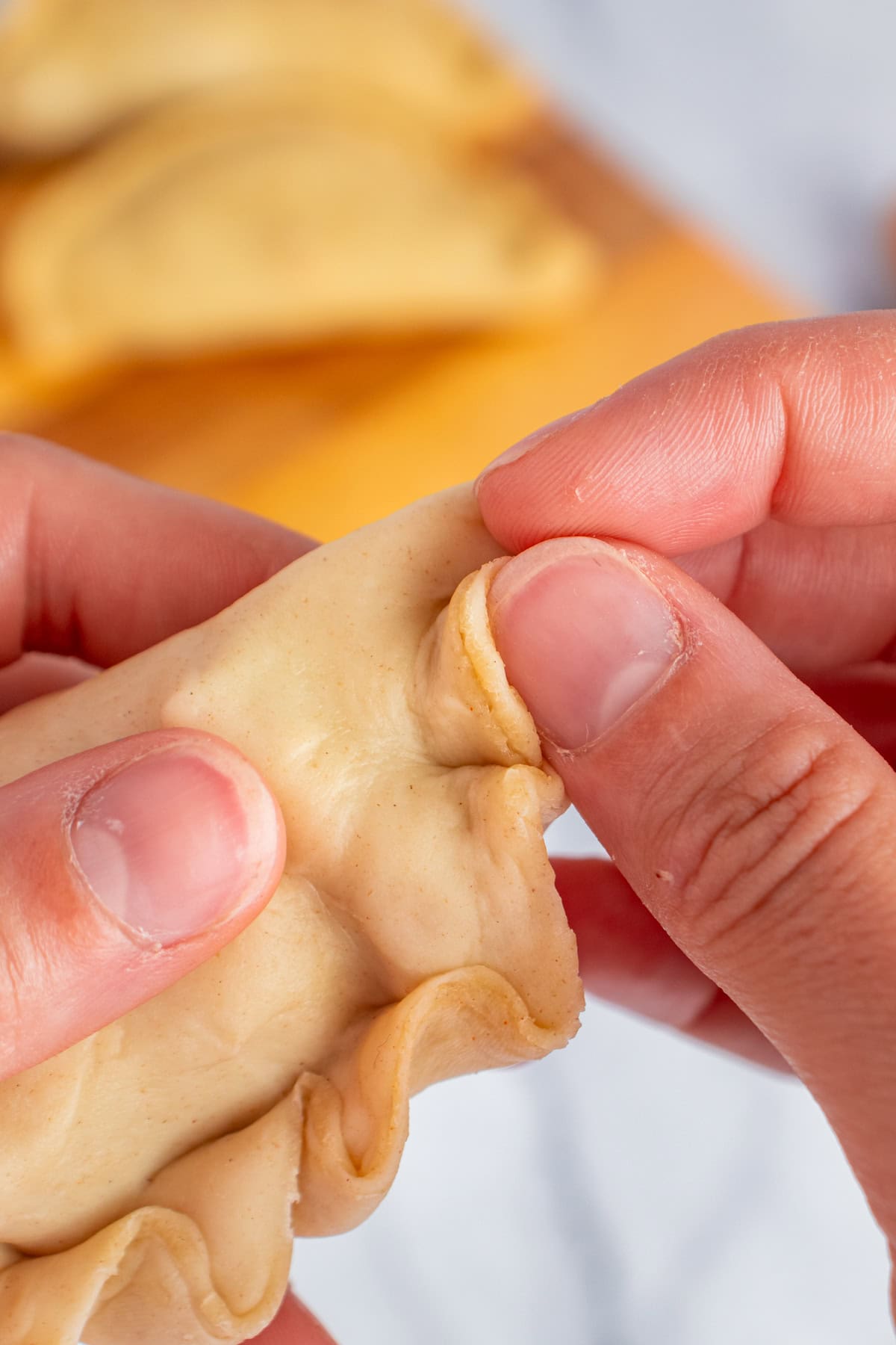 Folding and sealing empanadas.