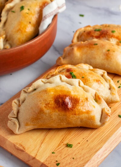 Chicken empanadas on a board.