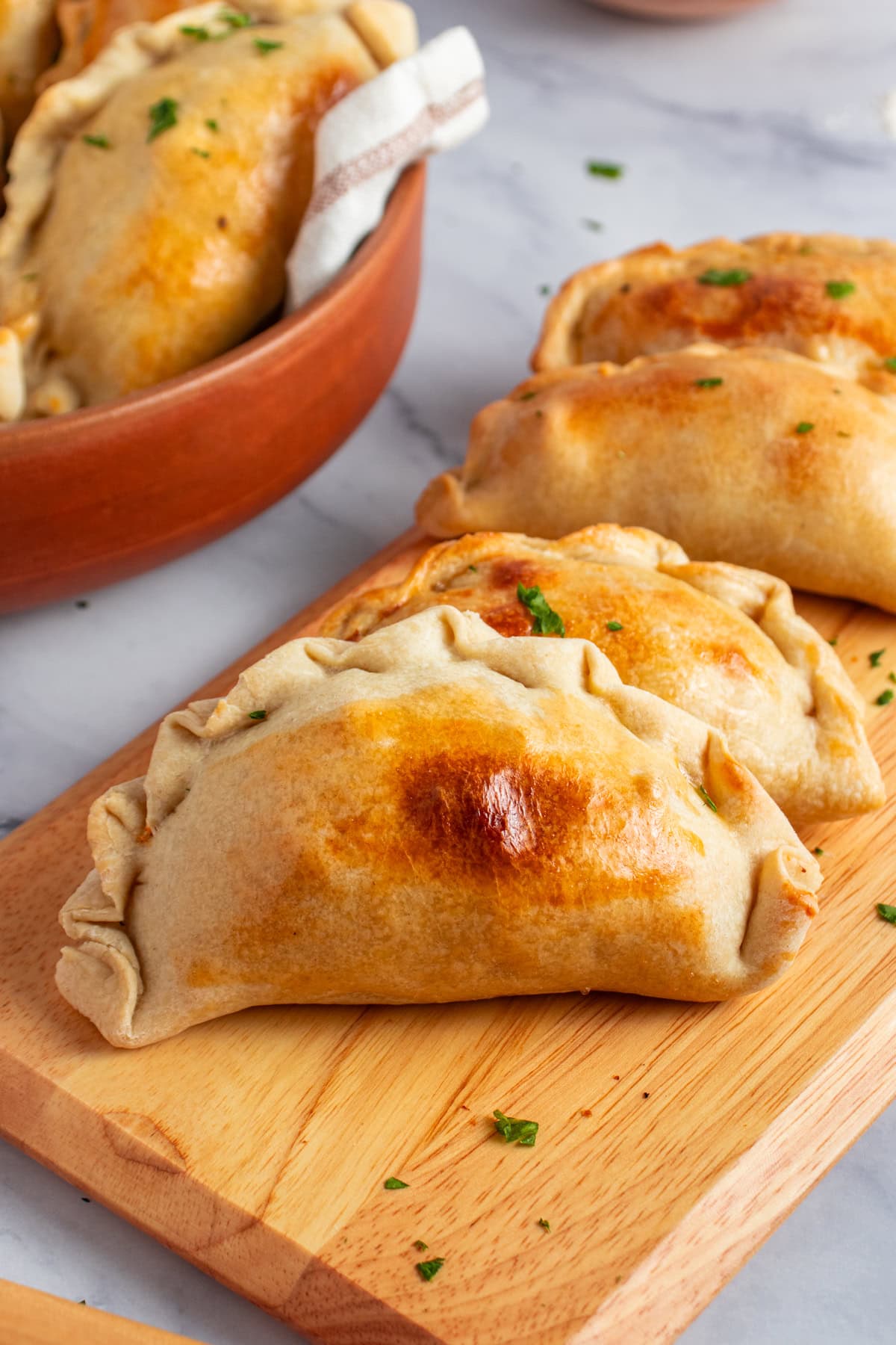 Chicken empanadas recipe on a wooden board.